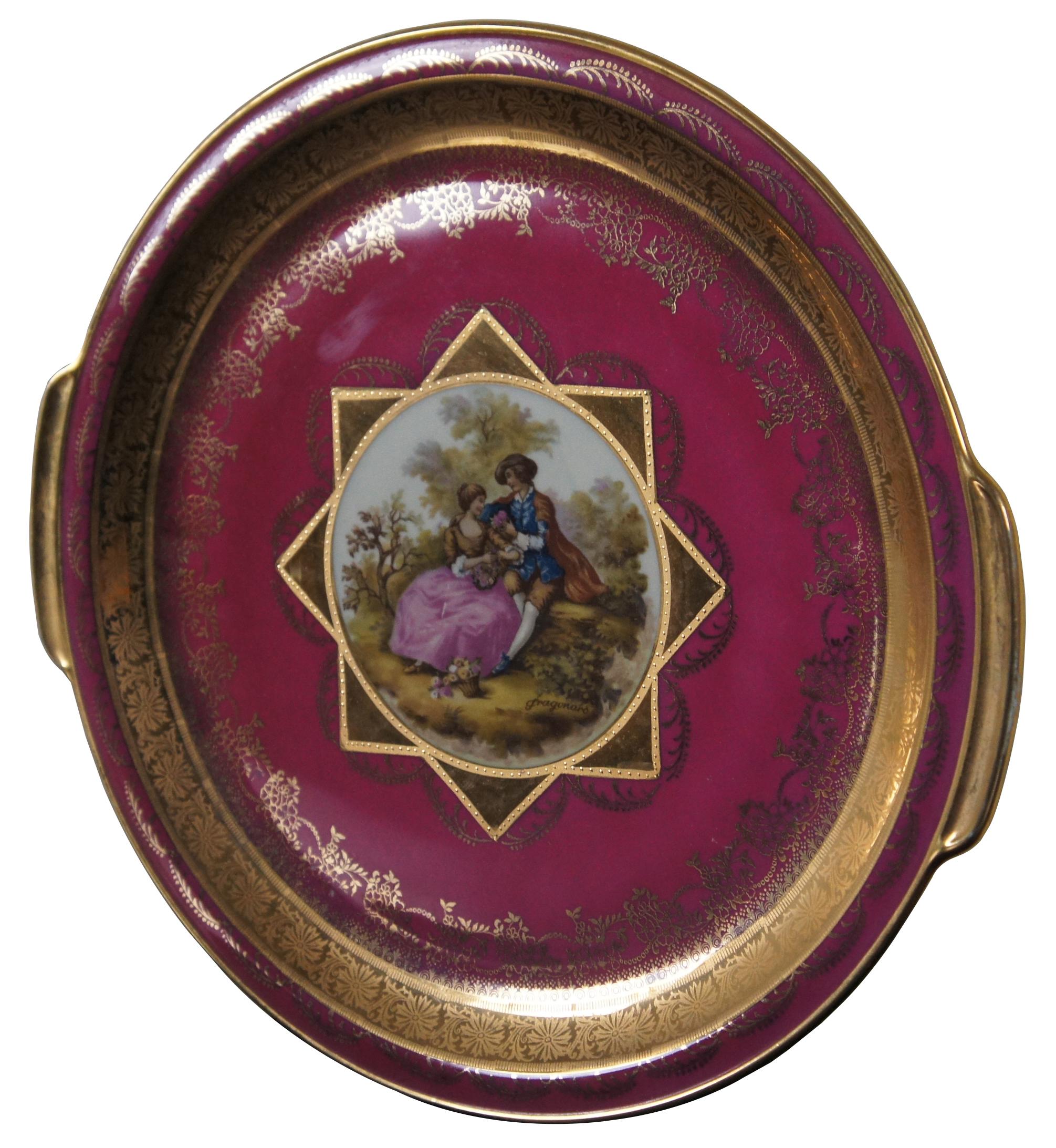 Antique Royal Bavaria Hutschenreuther Selb privat-decor portrait round platter / charger / plate with handles in magenta embossed with gold surrounding a scene of two lovers, by Dragonard. Measures: 12