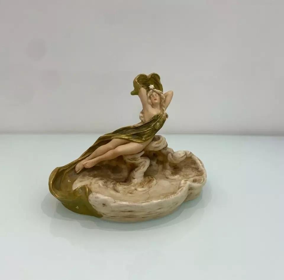 Une exquise sculpture ancienne en porcelaine Royal Dux, représentant une dame. 

Reflétant l'artisanat d'art de l'époque, il s'agit d'une belle pièce de collection et d'un étonnant objet de décoration.

Estampillé avec le signe Royal Dux en