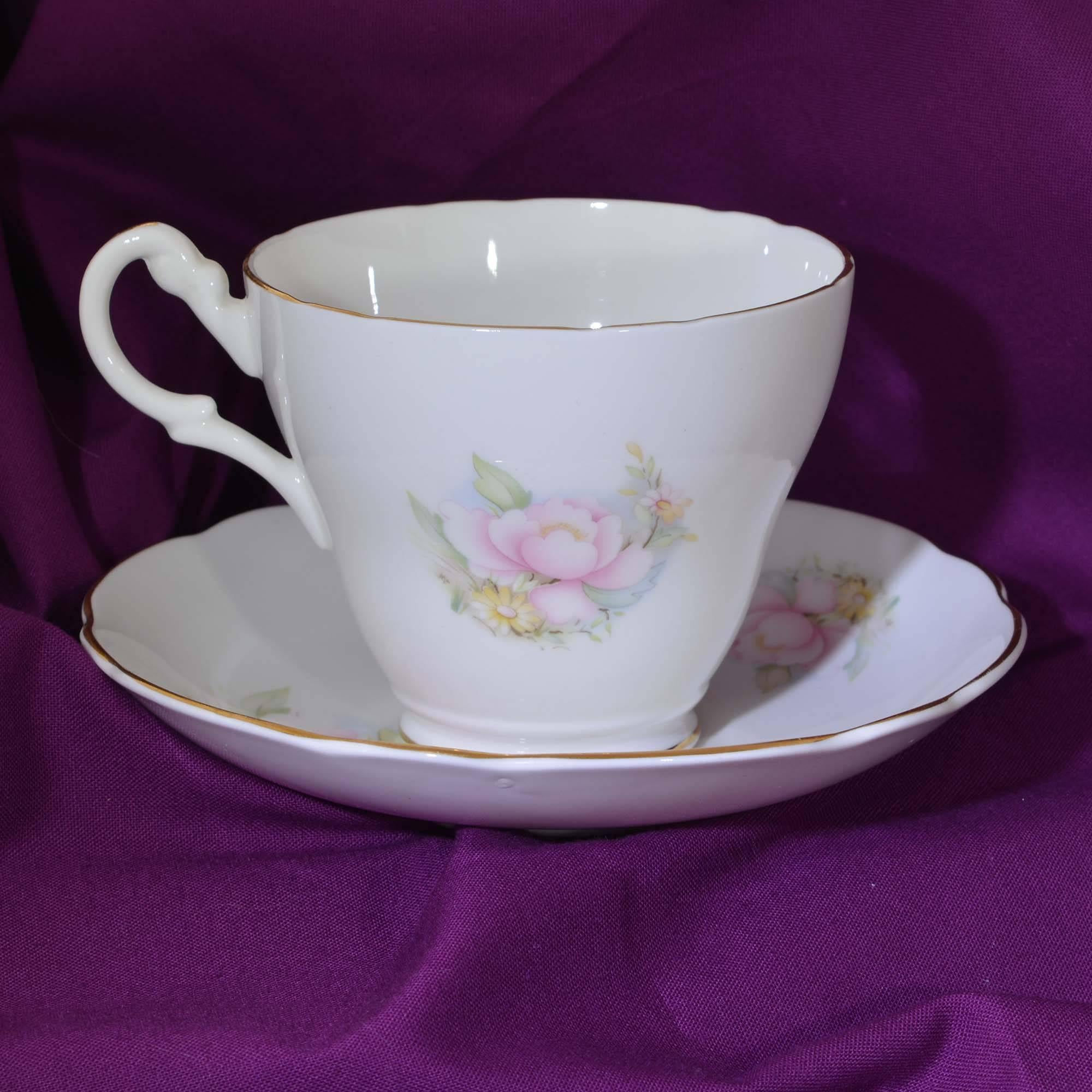 20 pieces of vintage Royal Stuart in the Pink Peonies pattern bone china tableware. This pattern was produced circa 1950. This pattern features a pastel peony motif with gilt rims. The slightly waved edges are trimmed with brushed gold.