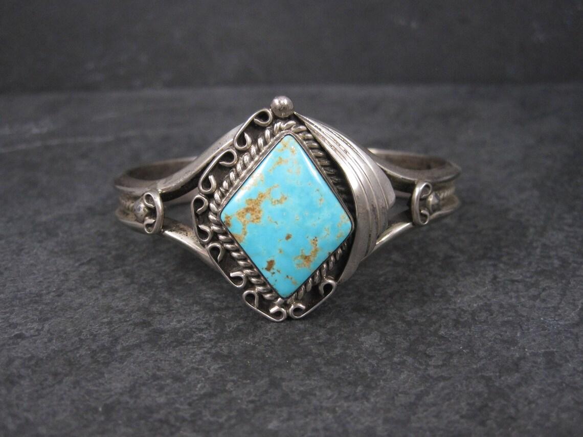 This bracelet features a turquoise from the Royston mine and is nothing short of gorgeous!!

Measurements:
The turquoise measures 20x25mm.
The face of the bracelet measures 1 3/8 by 1 1/4 inches.
The cuff is 10mm at its narrowest.

The inner