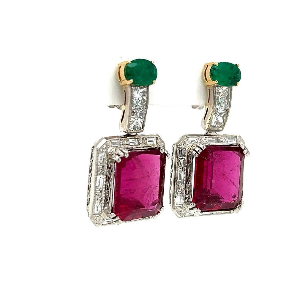 Simply Beautiful! Finely detailed and Elegant Rubellite Tourmaline, Diamond and Emerald Platinum Drop Earrings Securely Hand set with Rubellite, approx. 12.90tcw total weight of the 2 Rubellite. Surrounded by Sparkling Diamonds, approx. 1.80tcw.