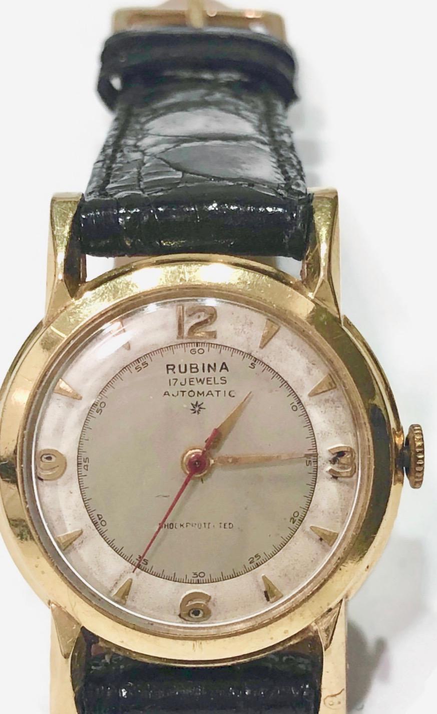 Vintage Rubina 14k yellow gold  watch with a round face and an automatic movement.  The watch is in the contemporary style with a  new black crocodile band.. 

The watch is in mint condition.  It would be categorized as a Mid-Sized watch.

Great for
