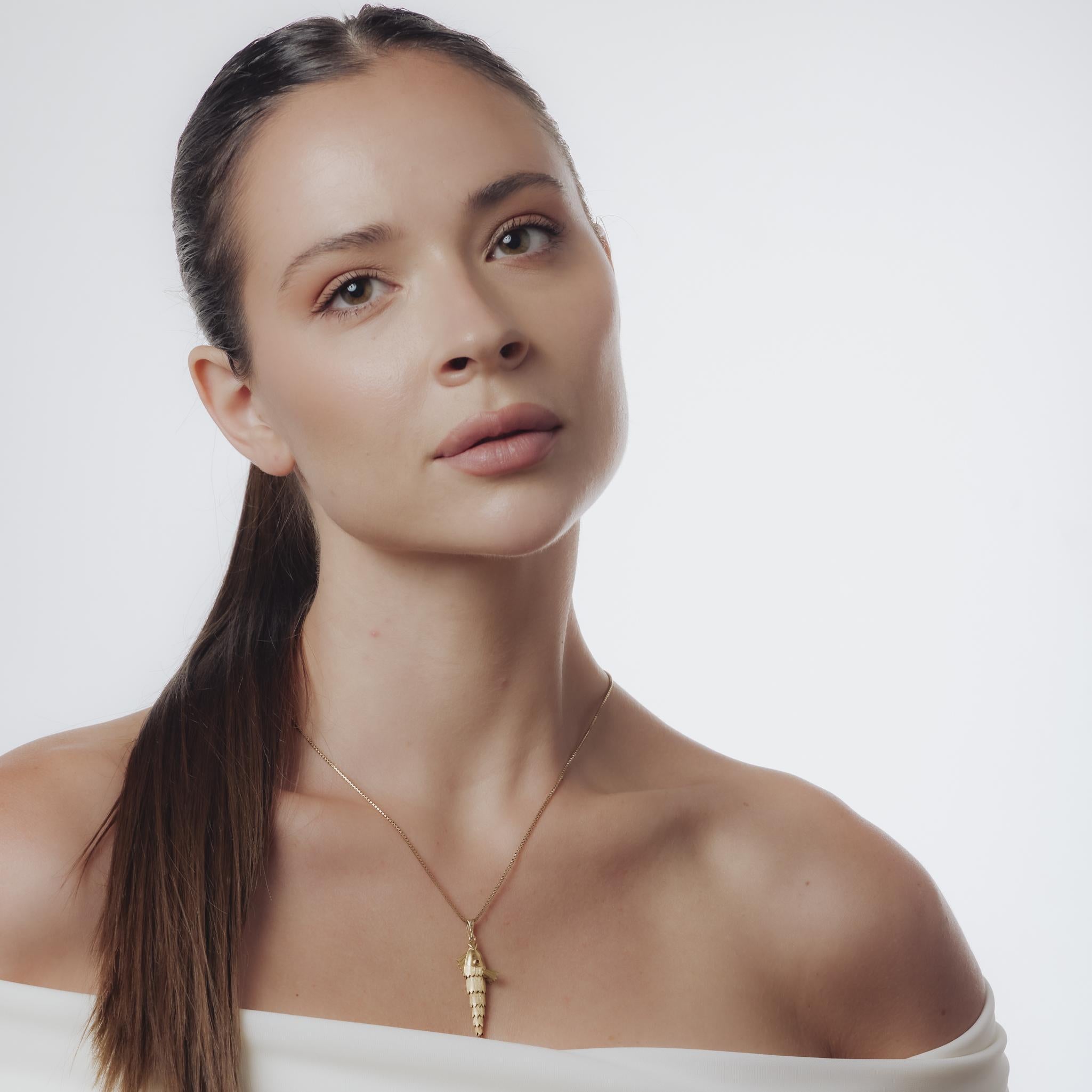 Ce collier vintage des années 1980 présente deux rubis ronds de taille brillante sertis dans un pendentif en or jaune 18 carats. Suspendu à une chaîne en or jaune 14k de 18,5 pouces poinçonnée 