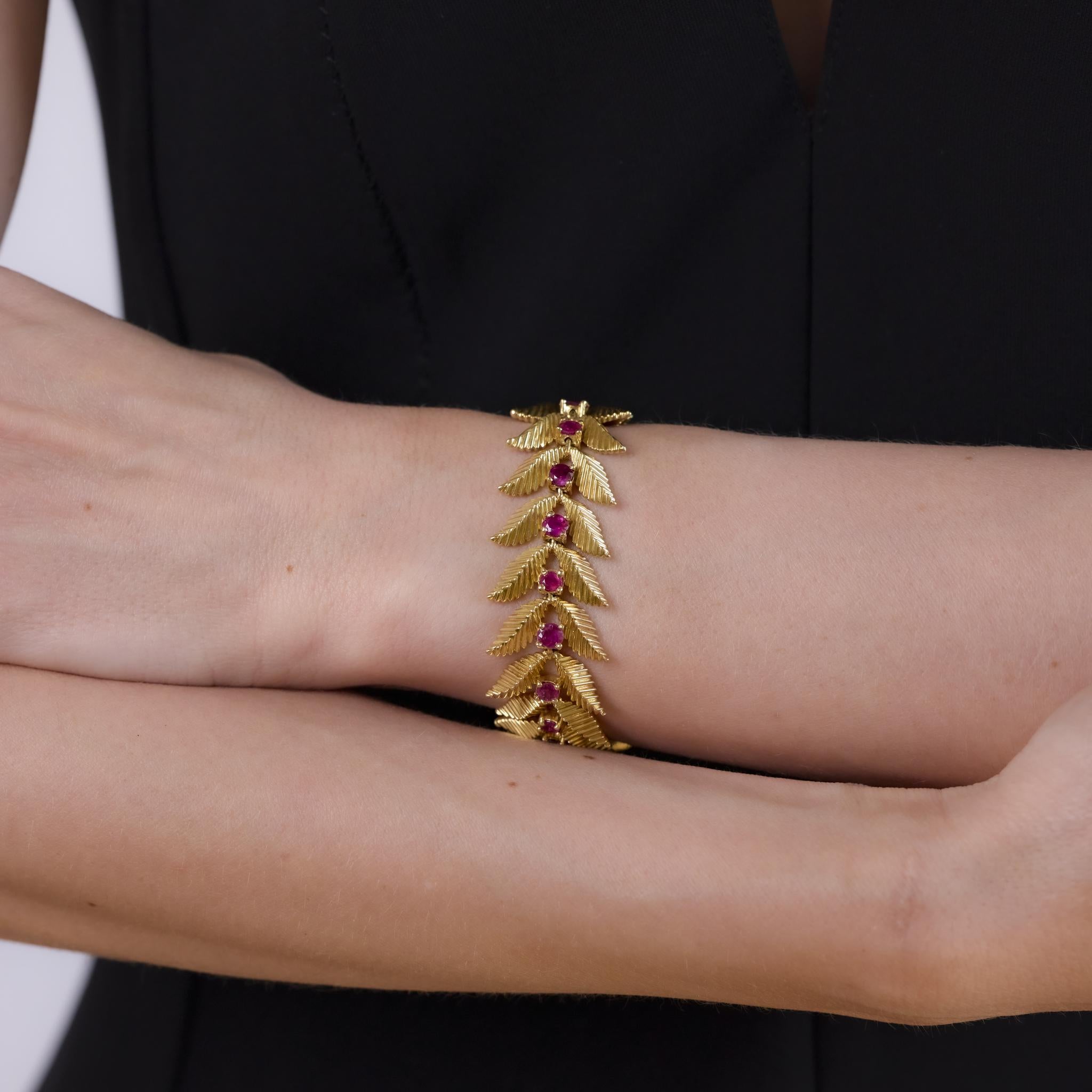 This vintage bracelet from the 1970s is crafted in richly polished 18k yellow gold and features 20 round cut rubies totaling approximately 12 carats. The vibrant rubies are set in bold gold links, creating a striking combination of color and weight.