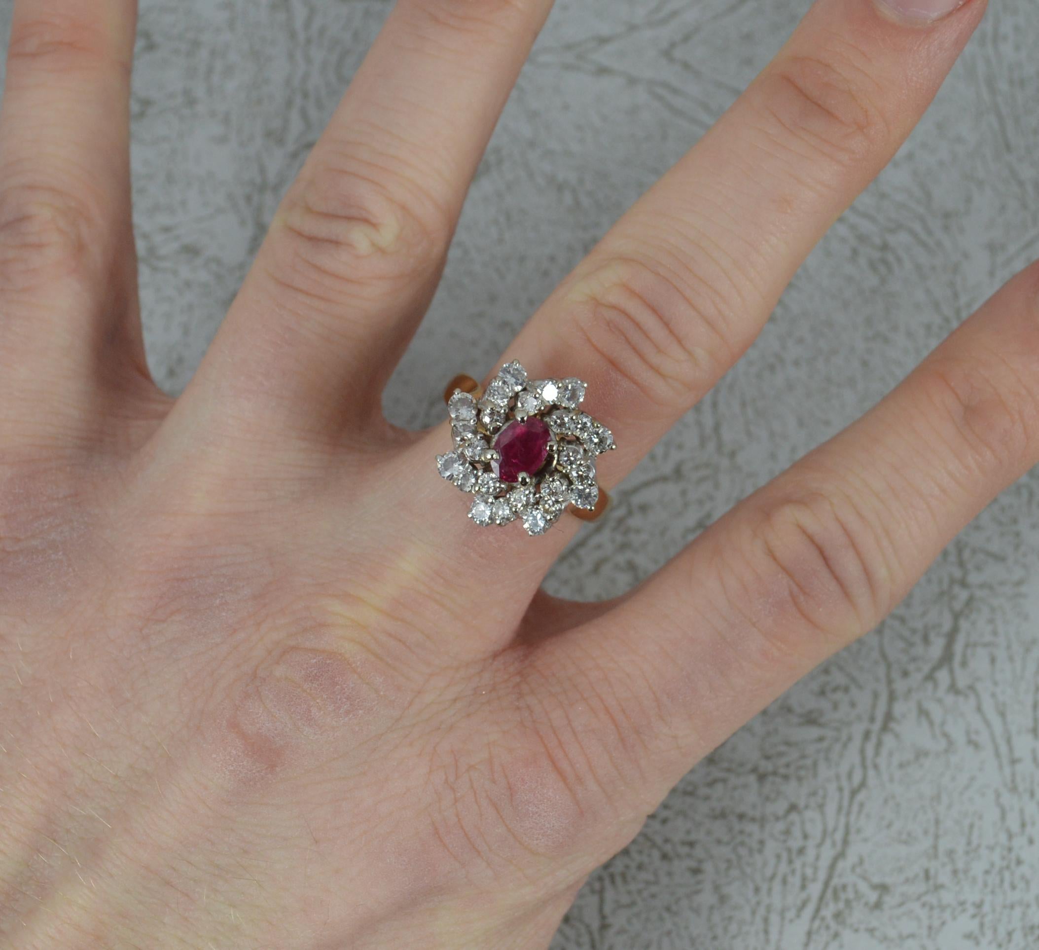 A stunning ladies cluster ring.
14 carat yellow gold shank and white gold head setting.
Designed with an oval cut ruby to the centre, 4.6mm x 6.5mm approx in a four claw setting. Surrounding are 24 natural round brilliant cut diamonds on a twist
