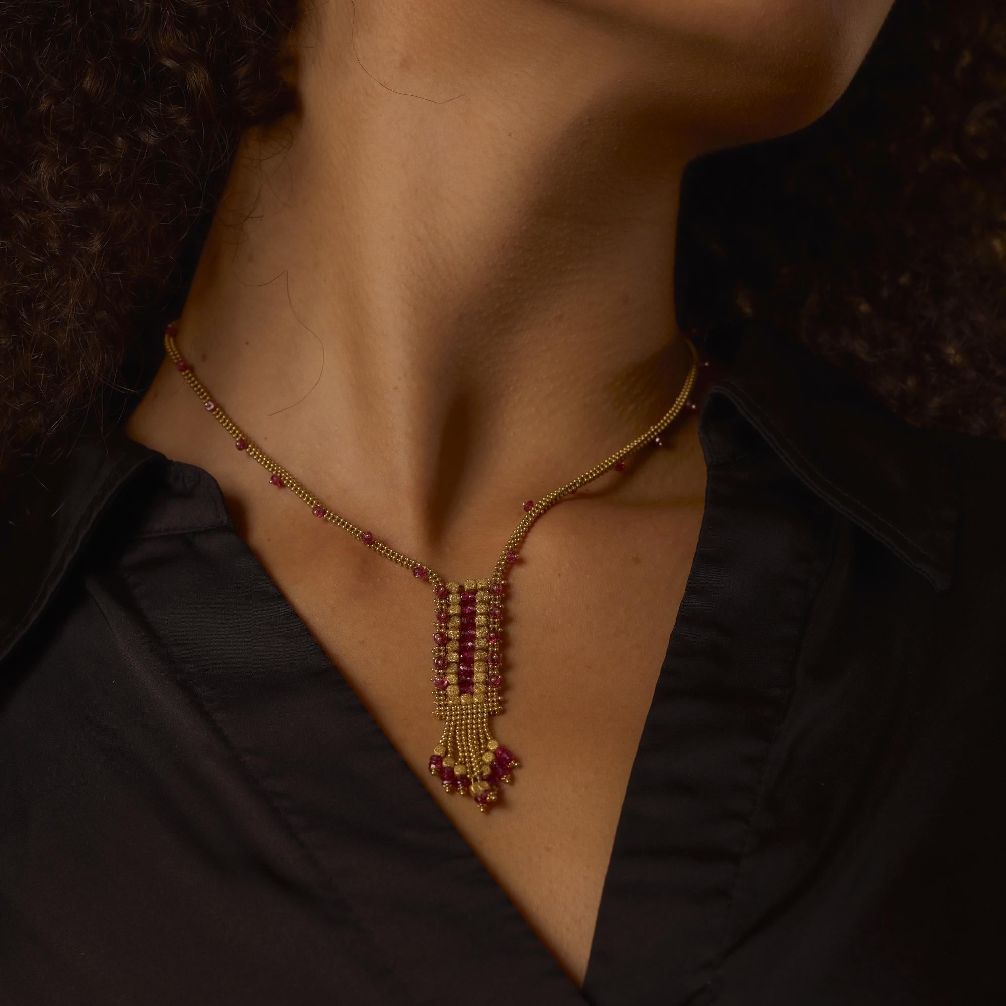 This vintage 18k yellow gold necklace showcases 67 shimmering briolette rubies, elegantly draped in a fluid, Italian-crafted silhouette full of vibrant color and movement.