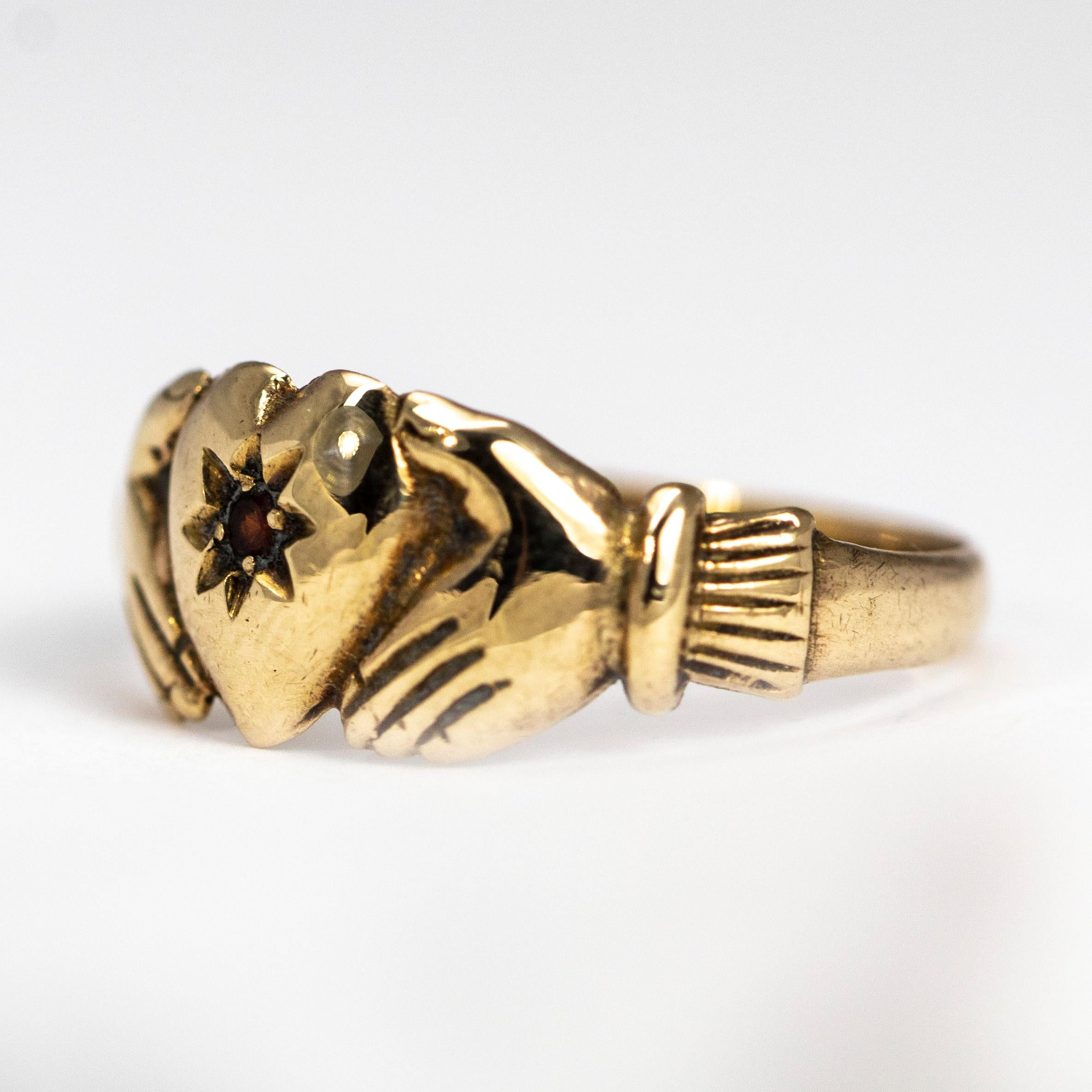 This ring is distinctive in that the bezel is cast to form two clasped hands that symbolise faith and trust. The heart at the centre holds a ruby and the ring is modelled in 9ct gold.

Ring Size: L 1/4 or 6
Widest Point: 7.5mm 

Weight: 1.74g