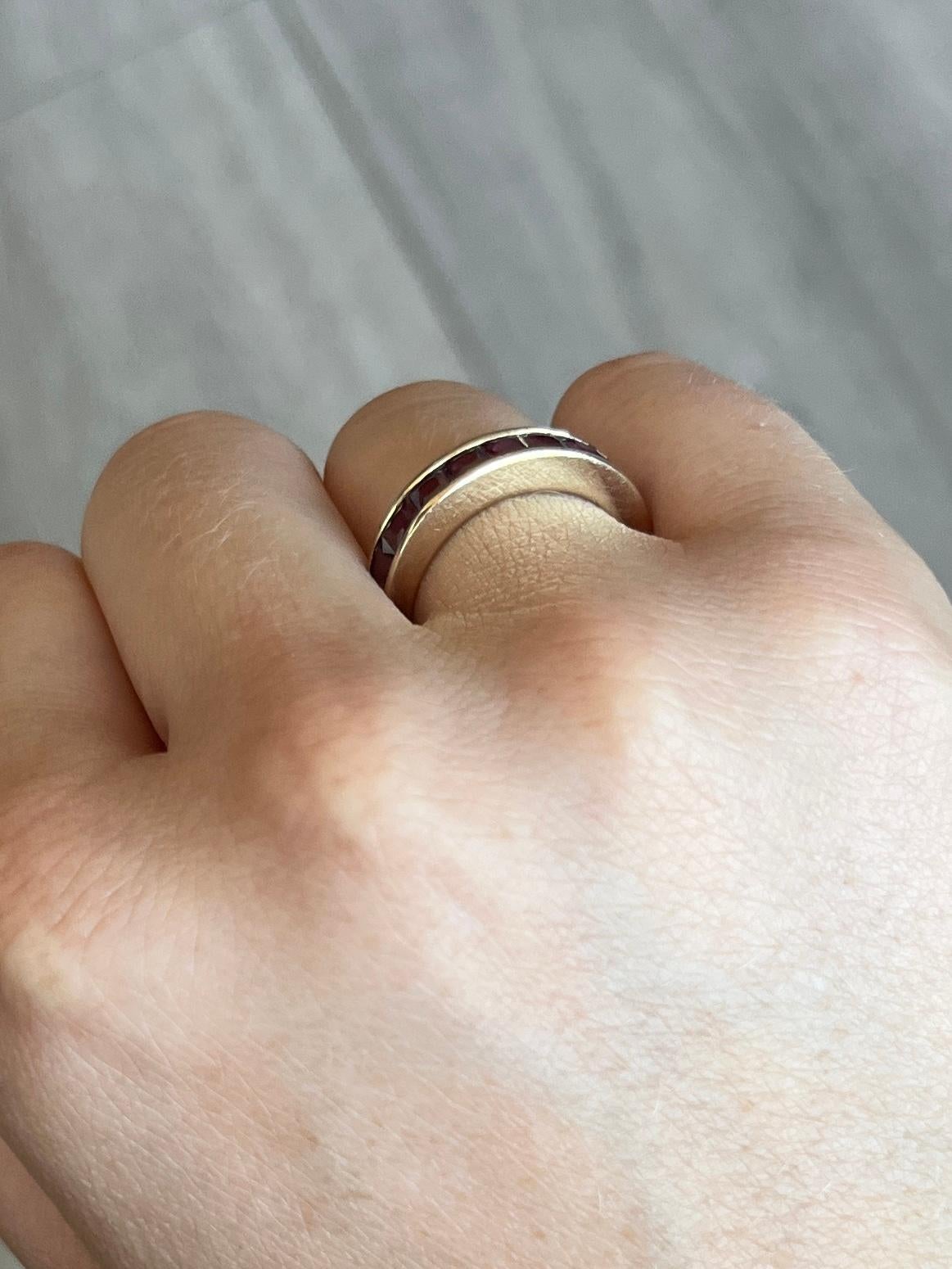 Diese schöne halbe Ewigkeit hält einen Streifen aus quadratisch geschliffenen Rubinen, die um die Hälfte des 9-karätigen Goldbandes reichen. Die 9 Rubine ergeben zusammen 90 Punkte. 

Ring Größe: L 1/2 oder 6  
Bandbreite: 4mm

Gewicht: 2,4 g