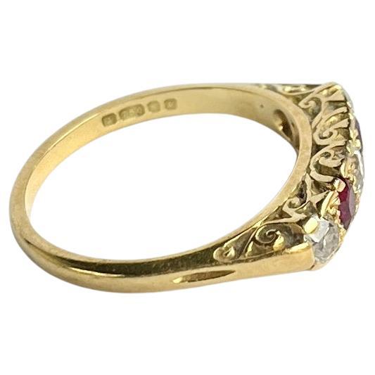 Set in this glossy 18ct gold ring are three Diamonds and two Rubies. The central diamond measures 15pts and the two outer diamonds measure 10pts each. The rubies total 30pts. The stones are set in simple claw settings and sit quite flush within the