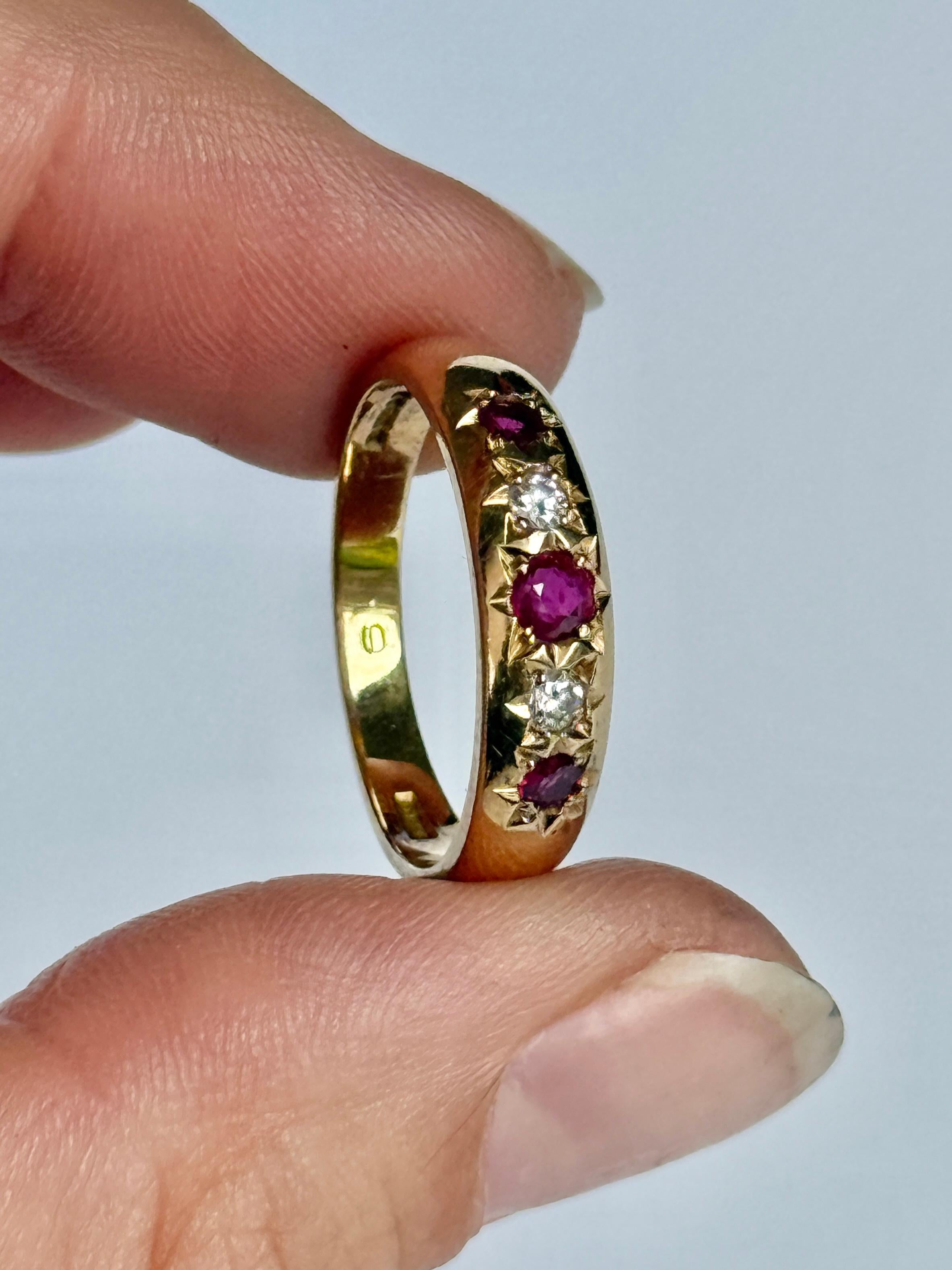 The central ruby in this glossy 18ct gold band measures 10pts. The rubies and diamonds that sit either side of this stone measure 5pts each. Fully hallmarked London 1986.

Ring Size: N 1/2 or 7
Band Width: 5mm 

Weight: 4.4g 