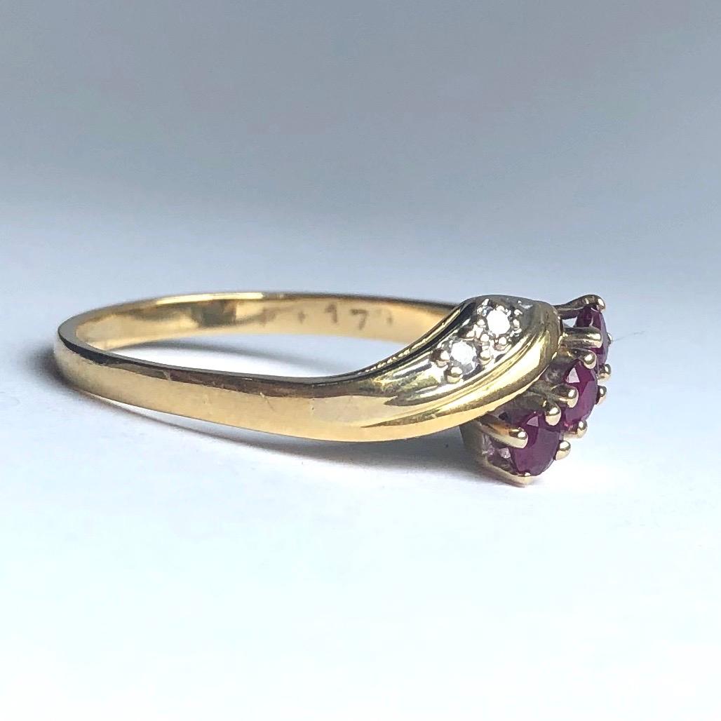 The three rubies sat at the centre of this ring are a deep pink colour and sit high above the two sweeping bands that sit either side of the three rubies. Either side of the rubies also sit two small diamonds totalling 12pts. 

Ring Size: O or 7 1/4
