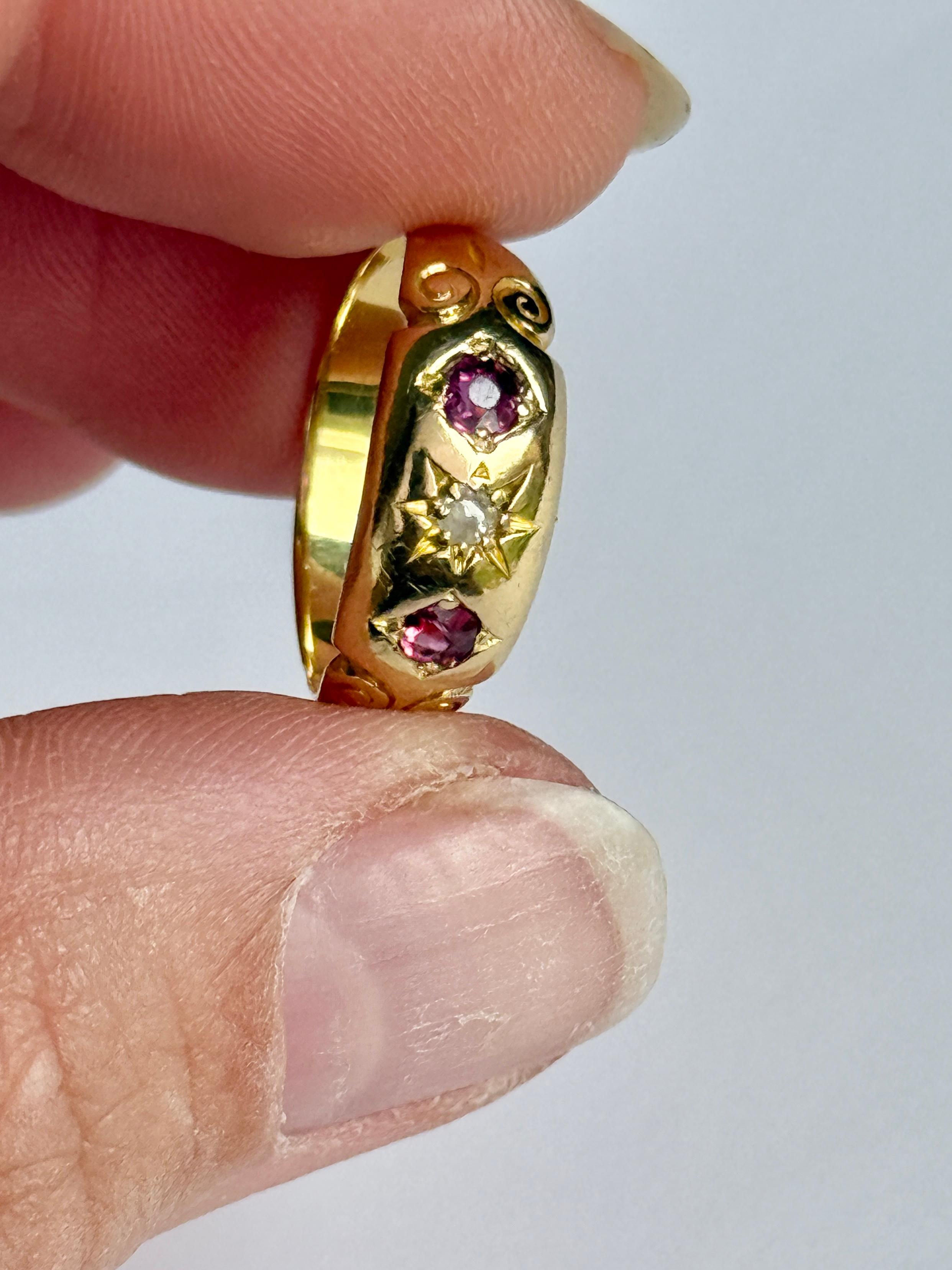 Der zentrale Diamant in diesem glänzenden 18-karätigen Goldband misst 5 Pence. Die Rubine, die auf beiden Seiten dieses Steins sitzen, messen jeweils 10 Pence.

Ringgröße: J oder 4 3/4
Breite des Bandes: 6,5 mm 

Gewicht: 2,7 g 