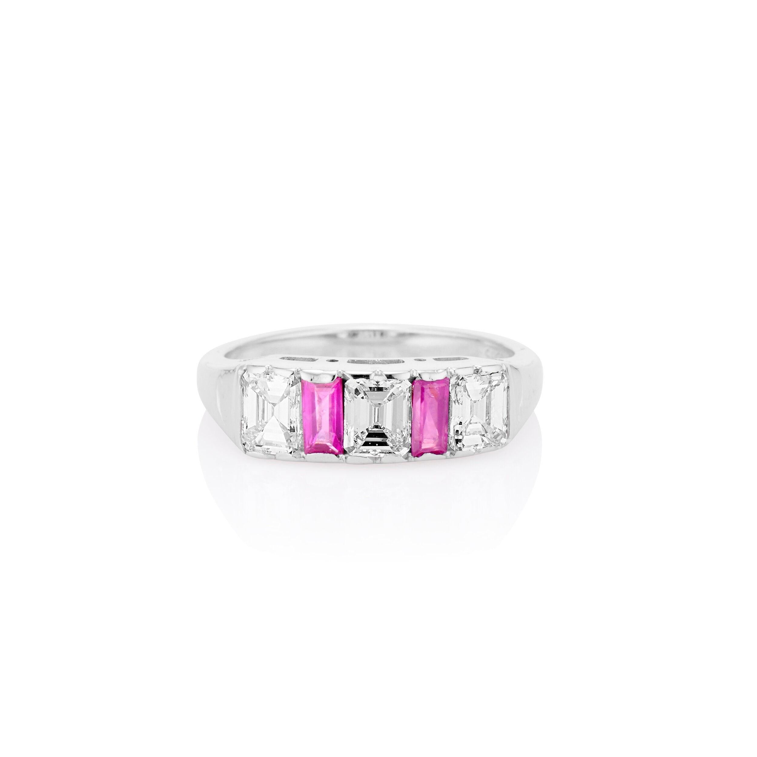 Dieser elegante und stapelbare Ring von HWBT & Sons aus den 1950er Jahren hebt drei nahtlos gefasste, strahlend weiße Diamanten im Smaragdschliff hervor, die von lebhaften natürlichen Rubinen umgeben sind. Dieser Ring aus 14-karätigem Weißgold hat