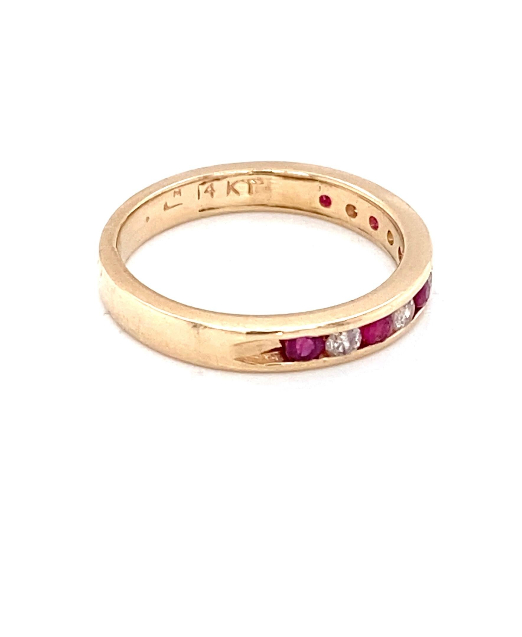 This vintage 14 karat yellow gold, ruby, and diamond ring features six (6) round rubies weighing approximately 0.24 carat total and five (5) round brilliant-cut diamonds weighing approximately 0.14 carat total with I color grade and I1 clarity