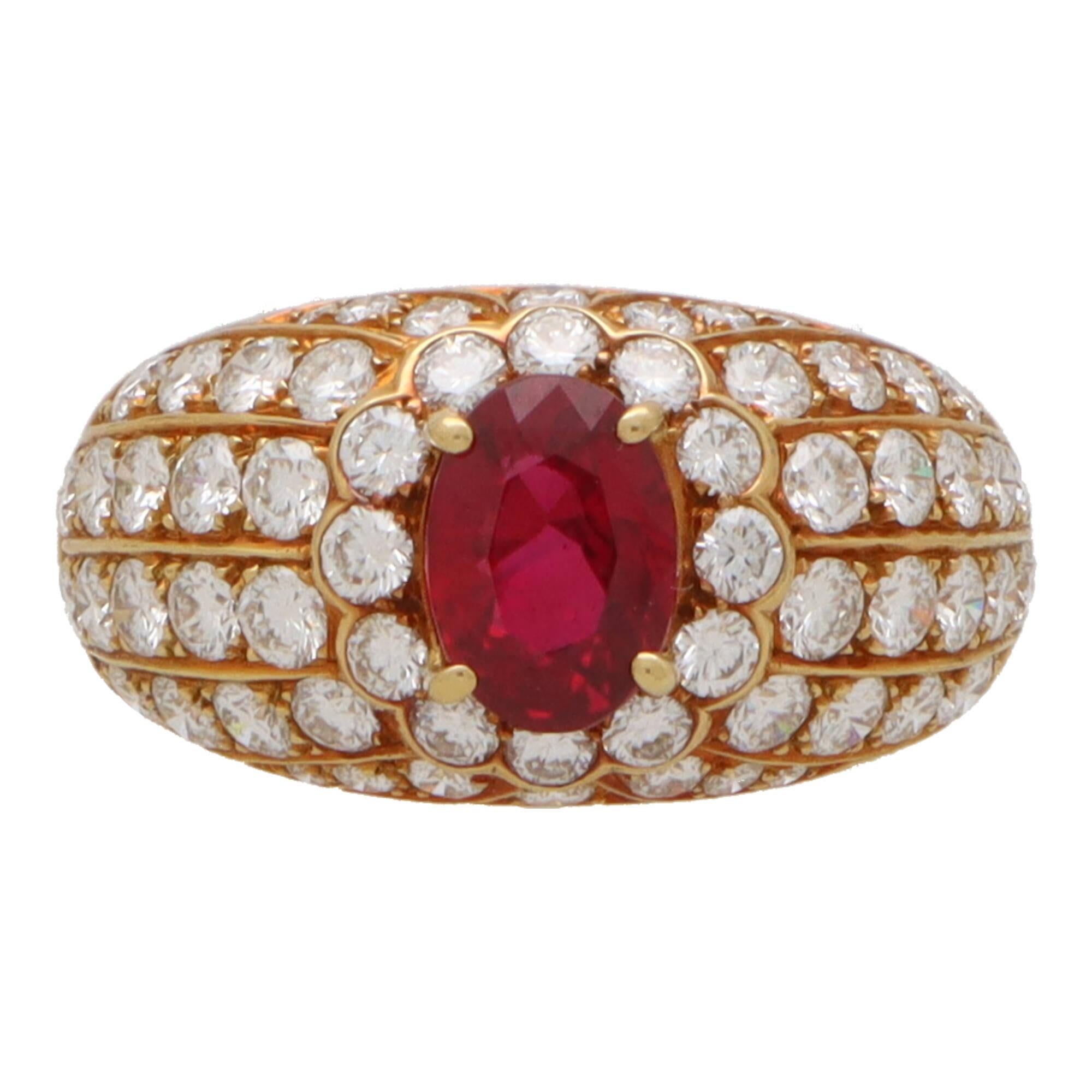  A beautiful vintage ruby and diamond cluster bombe ring set in 18k yellow gold.

This spectacular piece is composed in a bombe design and is centrally set with a vibrant oval cut ruby. The ruby is four claw set securely and surrounded by a cluster