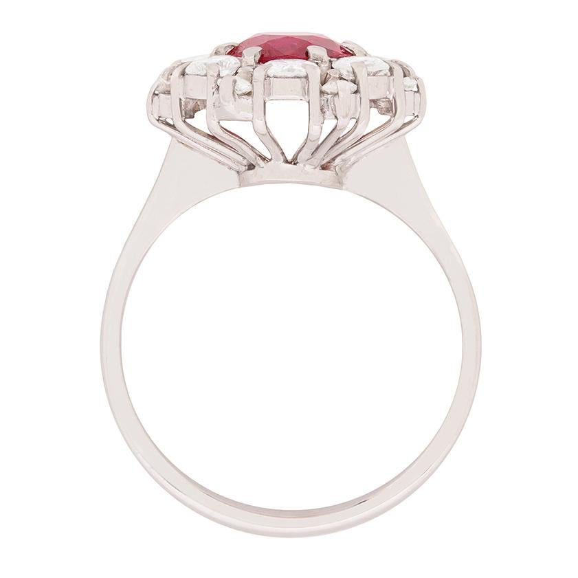 This stunning ruby ring dates back to the 1950s and is a typical dress ring of this era. It features a deep red ruby in the centre which weighs 1.65 carat, claw set using 18 carat white gold. Thie beautiful stone is the highlighted by a halo of