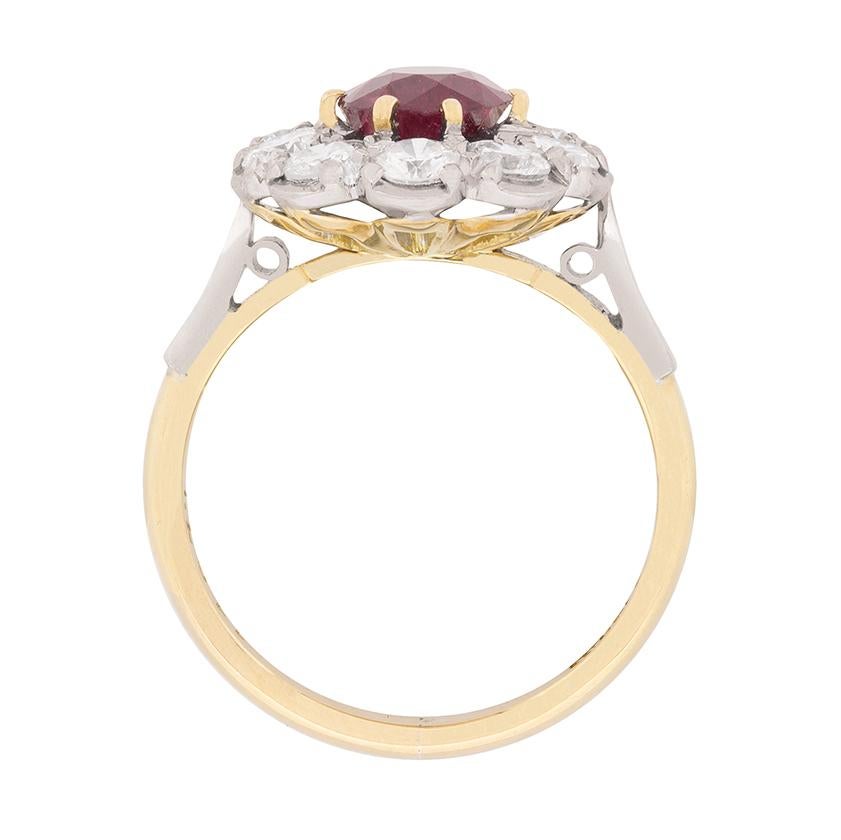 The centre stone of this cluster ring is a gorgeous deep red ruby, which is beautifully enhanced by a halo of diamonds. The ruby weighs 1.76 carat, and the ten round brilliants circling weigh 1.50 carat. The dazzling diamonds are G in colour and VS