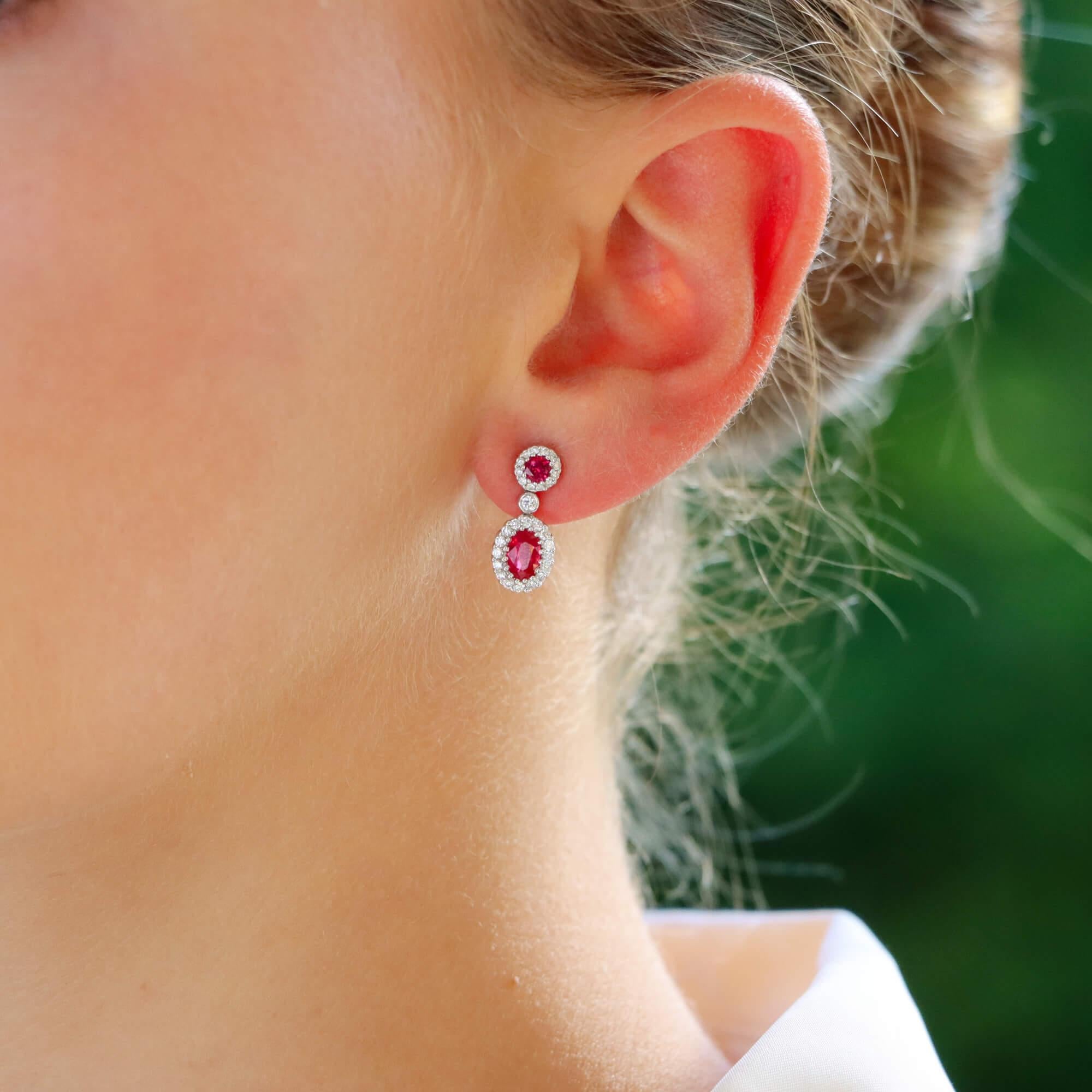 A beautifully pair of vibrant red ruby and diamond double cluster drop earrings set in 18k white gold.

Each earring is firstly composed of a traditional round ruby cluster ear stud, secured to reverse with a post and butterfly fitting. Hanging from