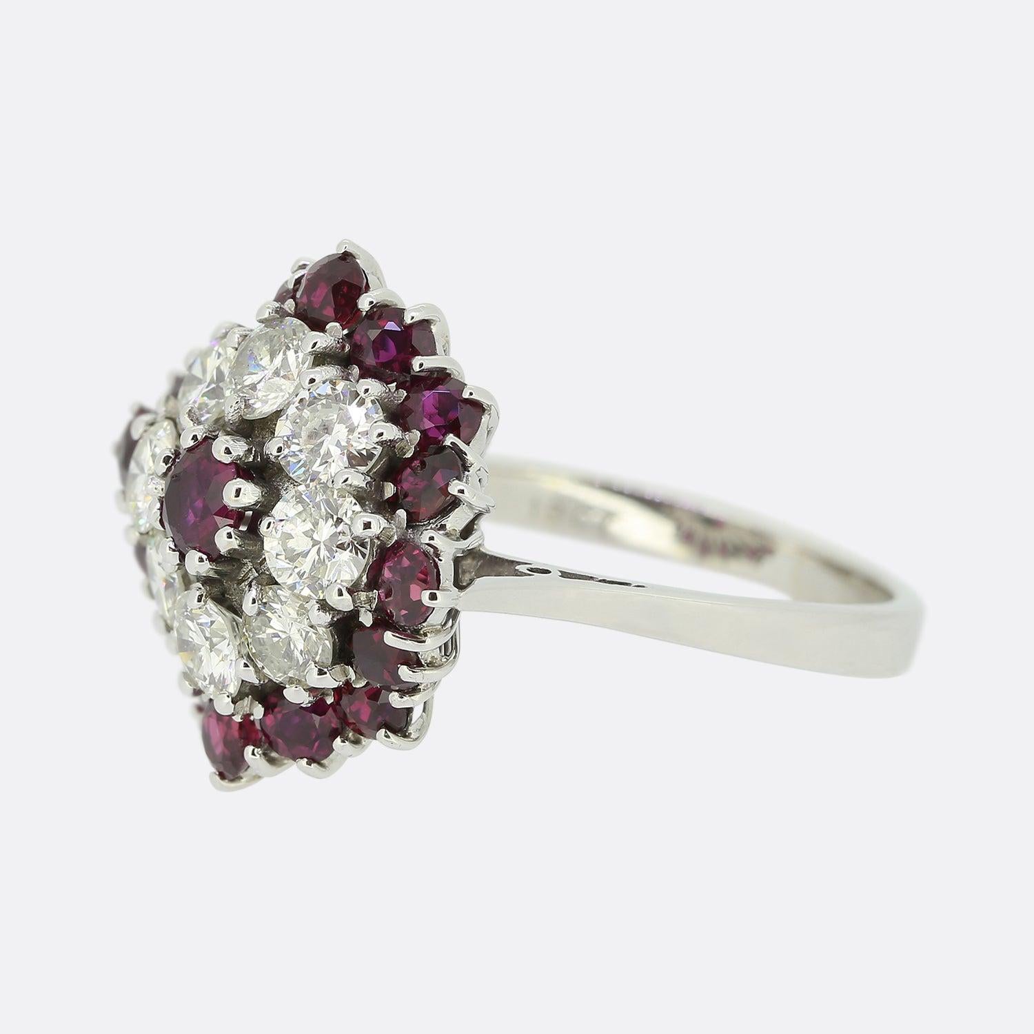 Here we have an excellently crafted dress ring showcasing a bold cluster of rubies and diamonds. Rendered in 18ct white gold, this piece features a single slightly risen ruby at the centre which is framed by, firstly, a circulating array of round