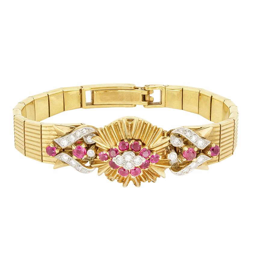 Cette étonnante montre de cocktail Jaeger-LeCoultre des années 1930 est fabriquée en or jaune 9 carats et conçue dans un style Art déco audacieux. Le cadran est caché sous un motif soleil orné d'un total de 1,70 carat de rubis vifs et de 0,52 carat