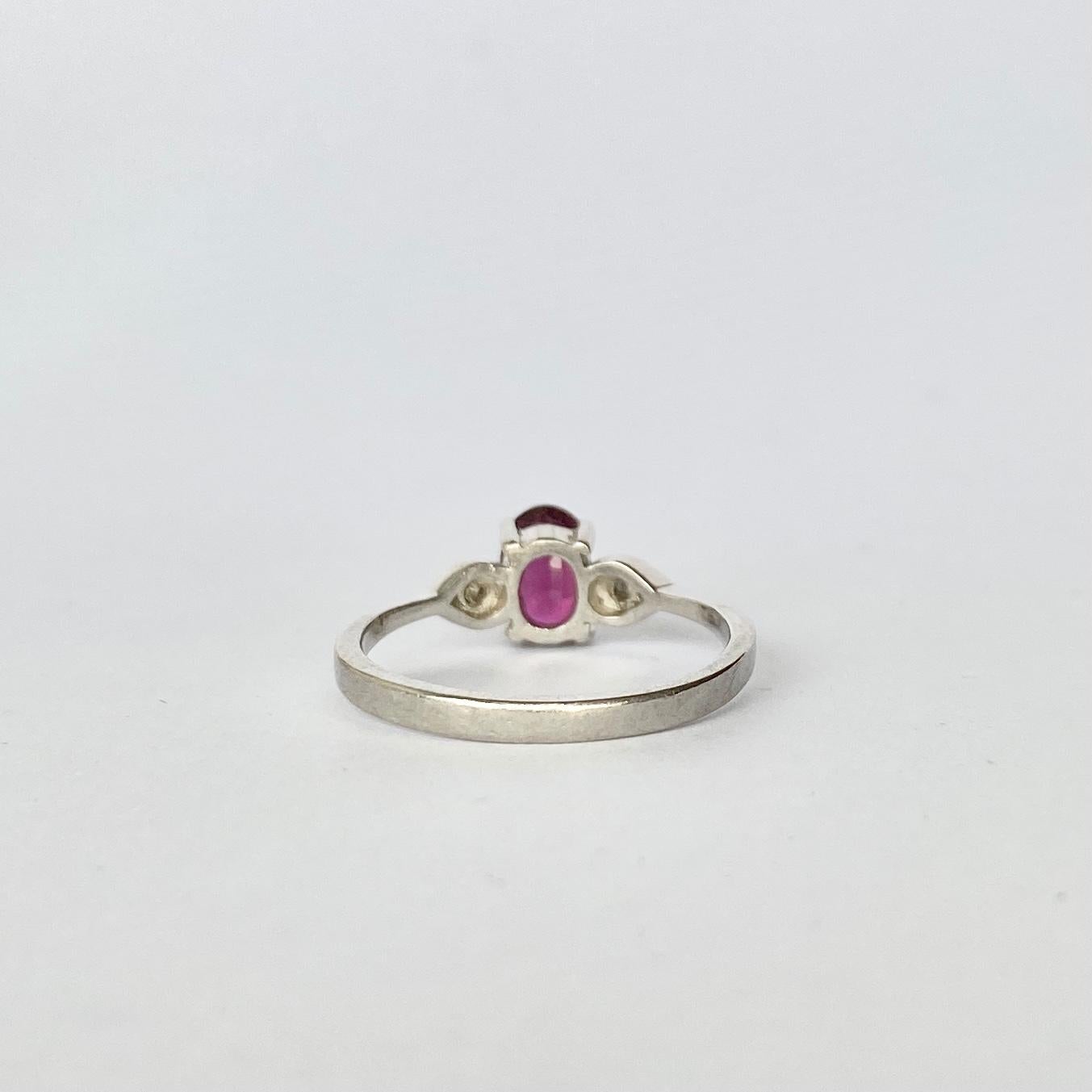 This three stone ring holds a ruby measuring 40pts and either side are two smaller diamonds which are bright and sparkly. Modelled in platinum. 

Ring Size: I 1/2 or 4 1/2 

Weight: 2.5g