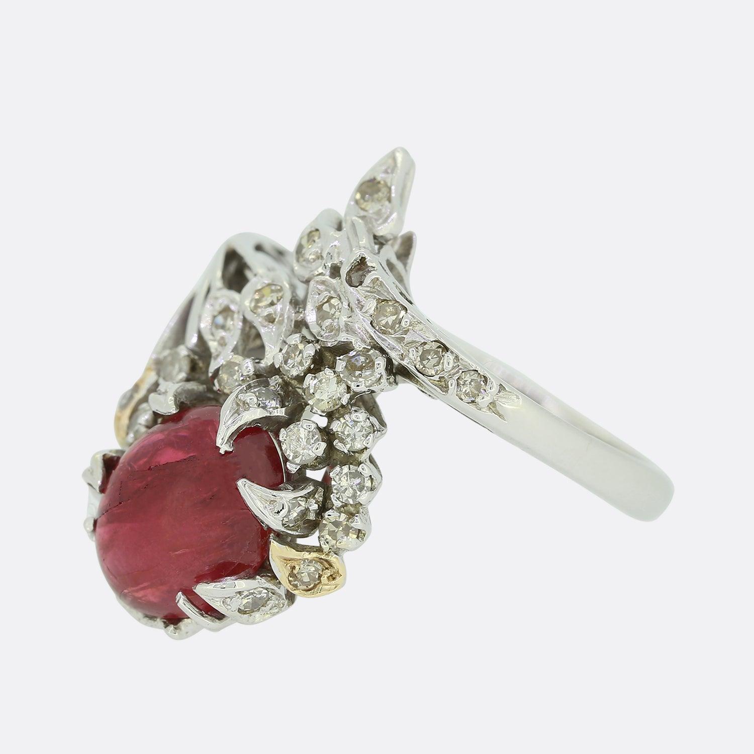 Dies ist eine wunderbare Vintage Rubin und Diamant-Ring. Der Ring zeigt einen großen Cabochon-Rubin, der von einer Gruppe von Diamanten im Einzelschliff umgeben ist, die in einer ungewöhnlich geformten, abstrakten Fassung aus 18 Karat Weißgold