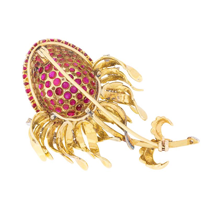 This beautiful brooch boasts a total of 10.00 carats of Burma rubies on the head of the Thistle. The grain set stones are a stunning red colour and work perfectly with the 18 carat yellow gold setting work. The metal work continues into the stalk