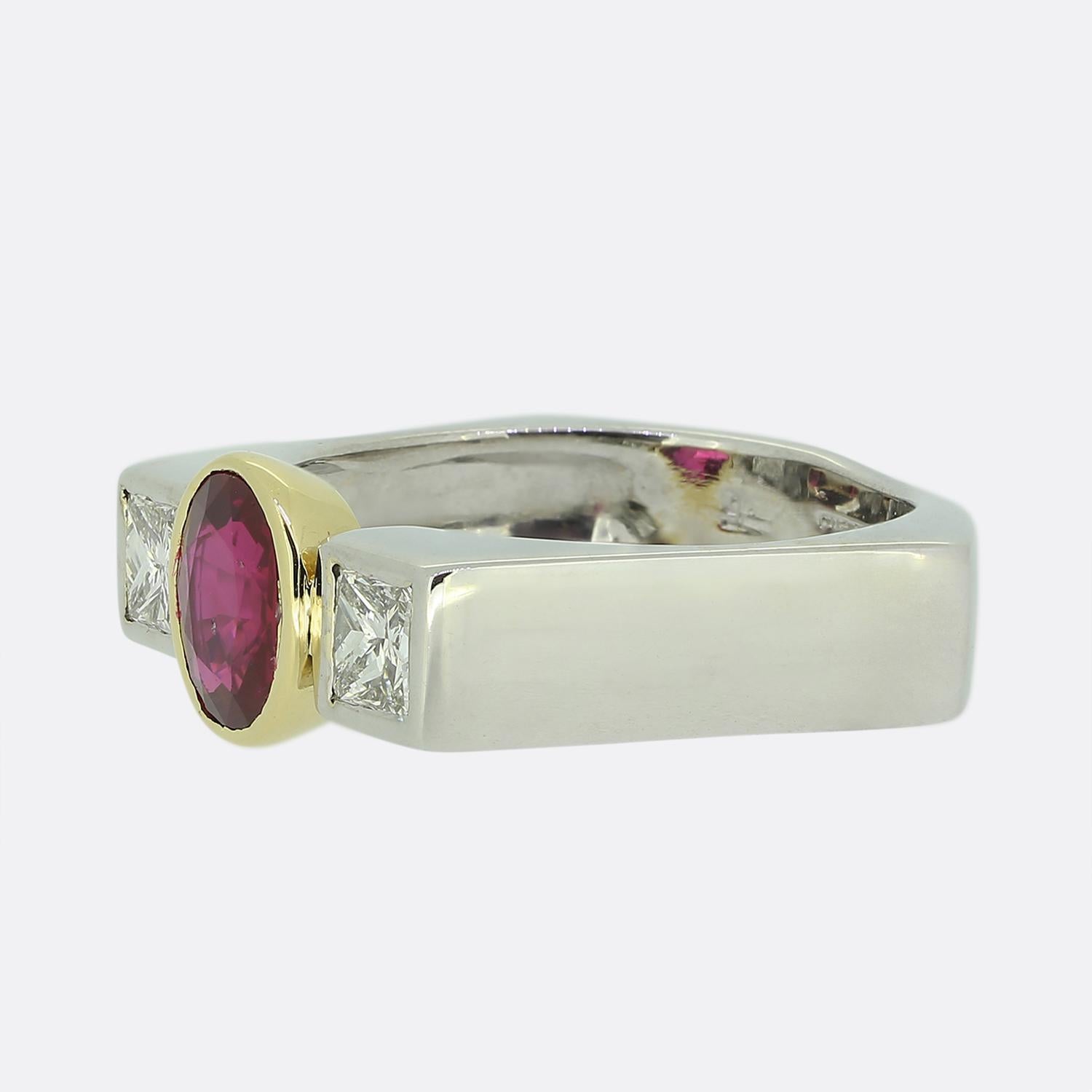Aquí tenemos un encantador anillo de tres piedras. Esta pieza vintage ha sido elaborada en oro blanco de 18 ct y lleva un único rubí natural oval facetado en el centro de la cara. Esta piedra principal posee un tono rojo intenso muy acentuado a