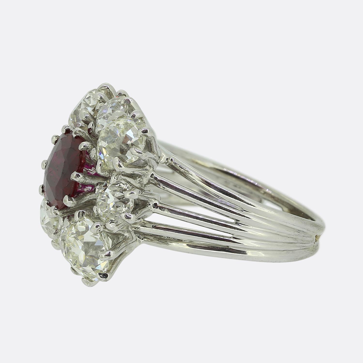 Here we have a truly wonderful ruby and diamond ring that dates back to the 1950s. The ruby is a highly desirable rich red hue and is surrounded by a cluster of chunky old cut white diamonds. The ring is crafted in platinum and has elegant tapered