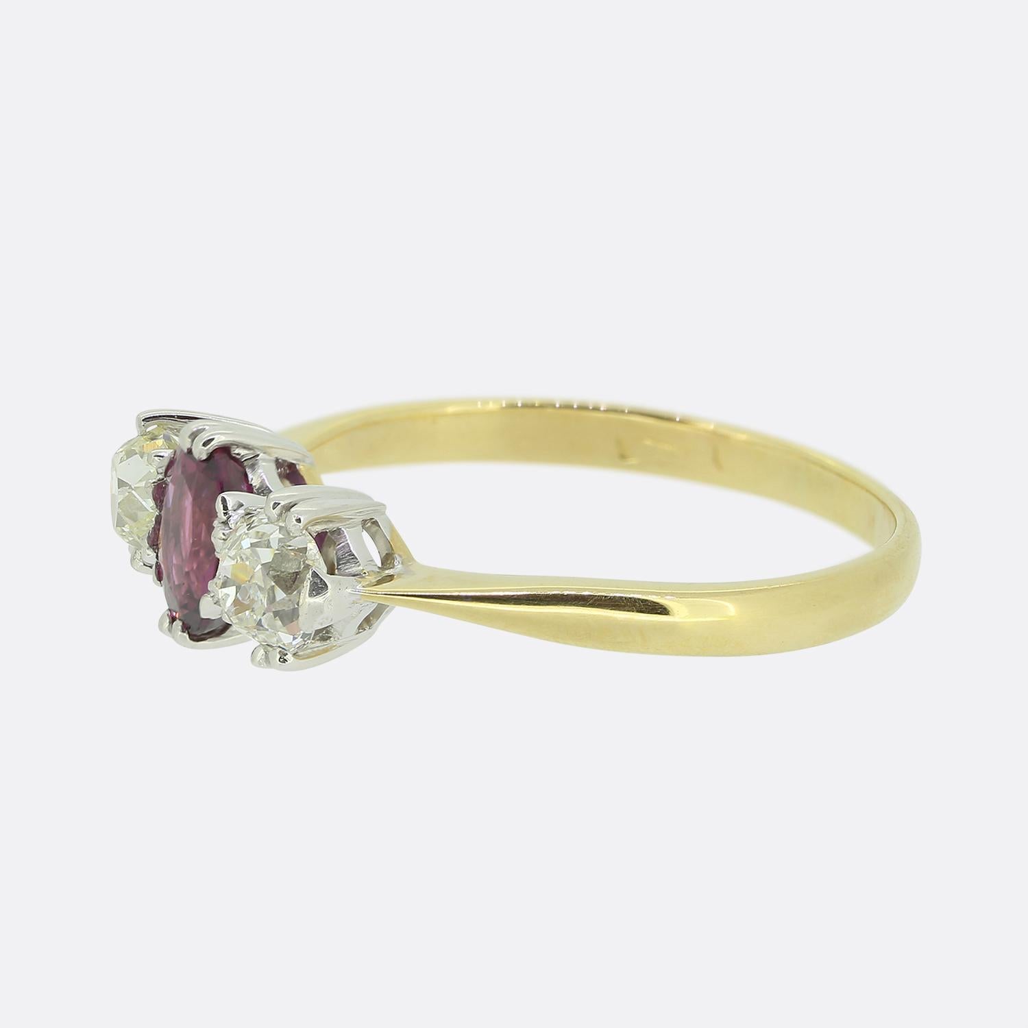 Here we have a classically styled three-stone ring. This vintage piece has been crafted from 18ct yellow gold with an oval faceted rich red ruby focally positioned at the centre. Flanking this principal stone on either side is a single round faceted