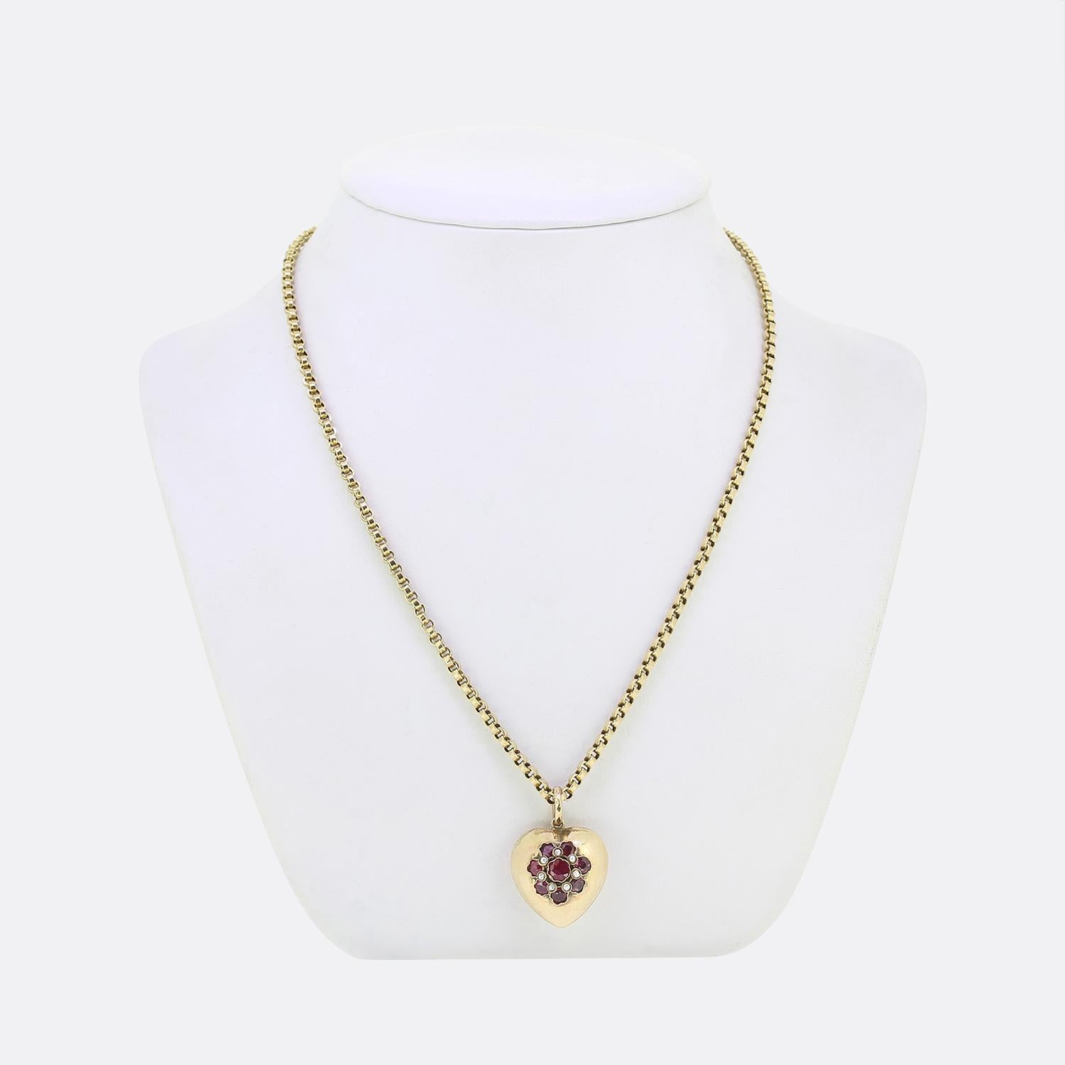 Here we have a charming ruby and pearl necklace. This vintage piece has been crafted from 9ct yellow gold with the pendant forming the shape of a love heart. This hollow motif plays host to a daisy-like array of round faceted rubies; each of which