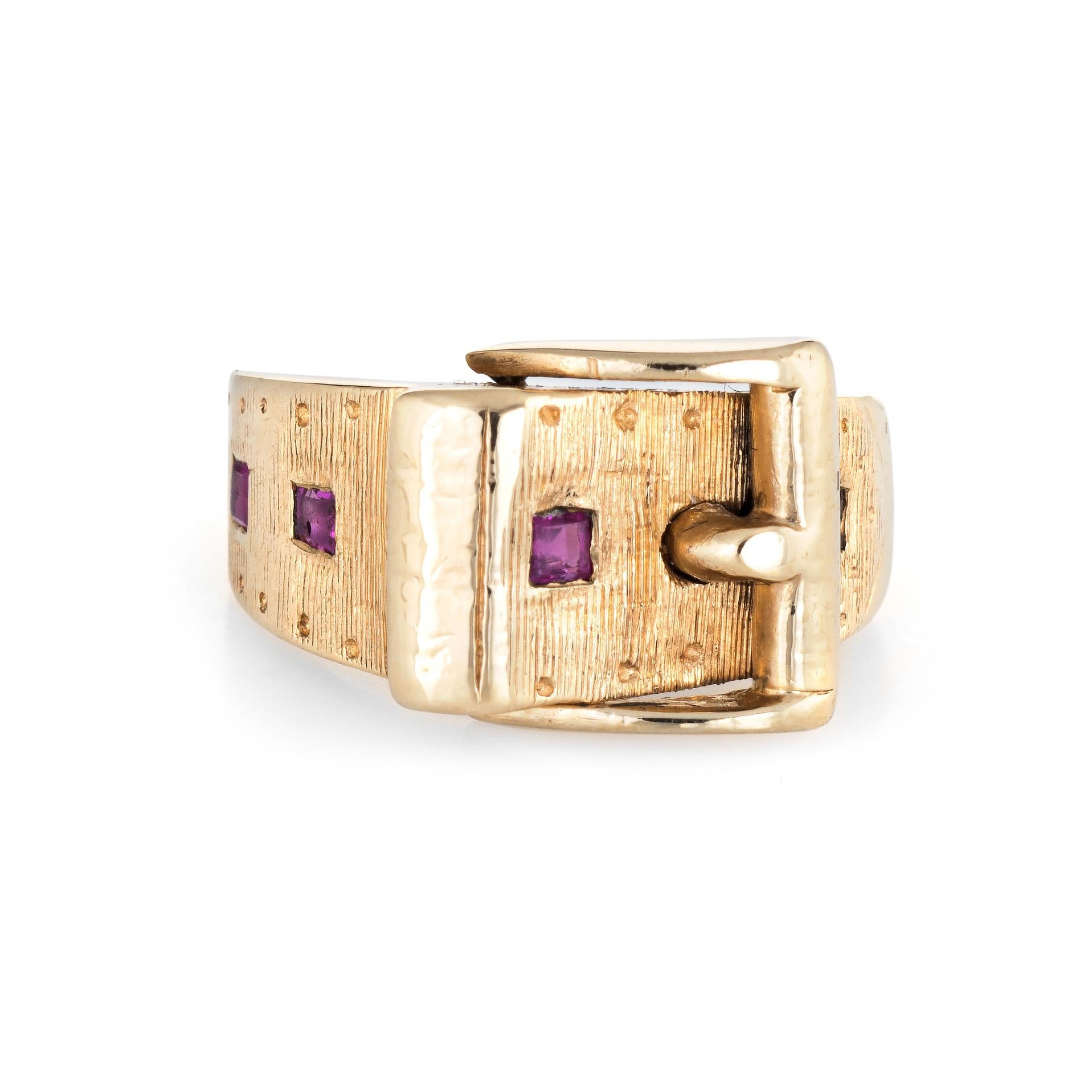 Stylish vintage buckle ring ring (circa 1960s to 1970s) crafted in 14 karat yellow gold. 

Four estimated 0.03 carat box cut rubies are set into the band. The total ruby weight is estimated at 0.12 carats. 

The stylish buckle ring features a