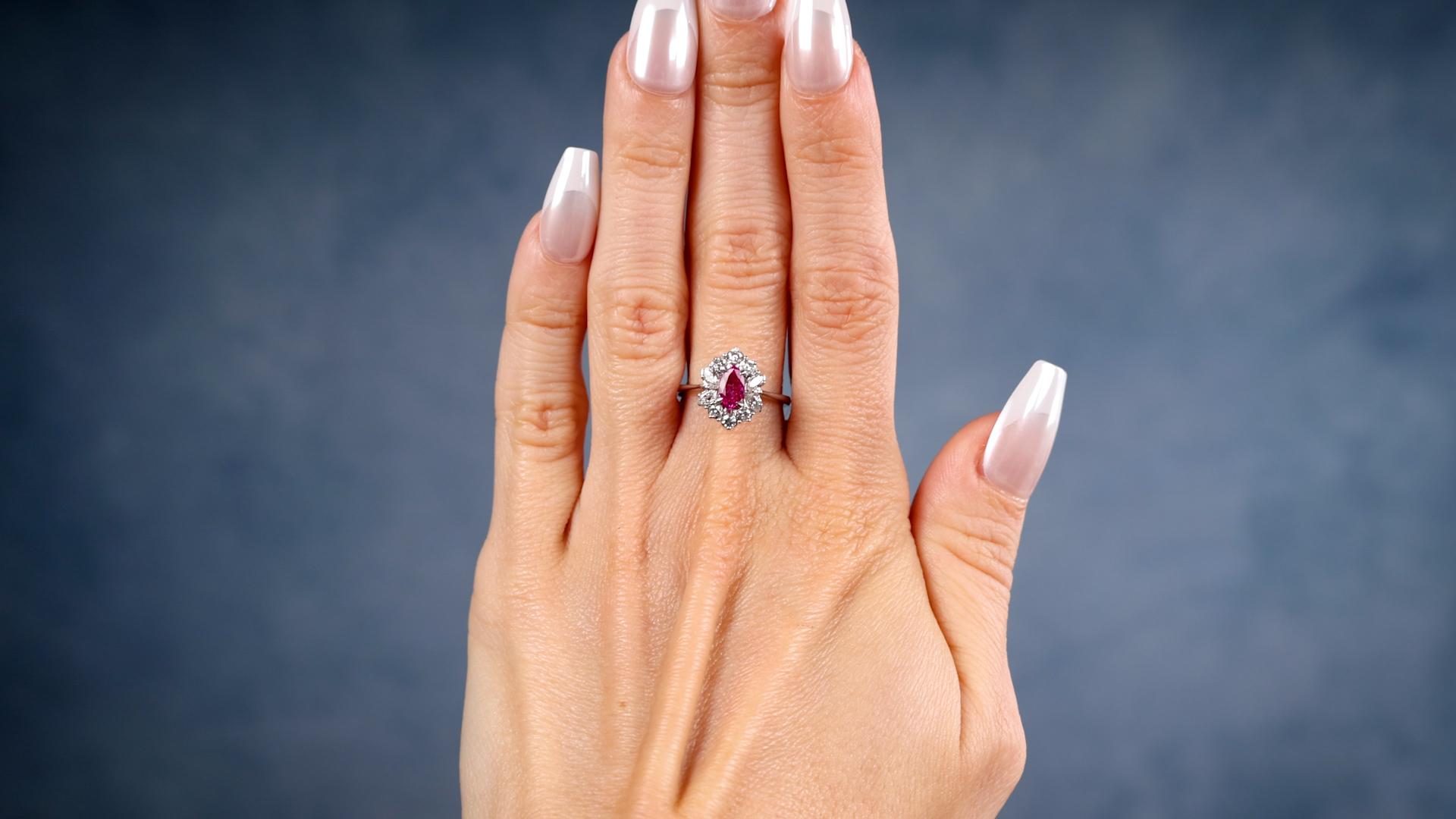 One Vintage Ruby Diamond 18k White Gold Cluster Ring. Featuring one marquise cut ruby weighing approximately 0.55 carat. Accented by six round brilliant and four marquise cut diamonds with a total weight of approximately 0.25 carat, graded