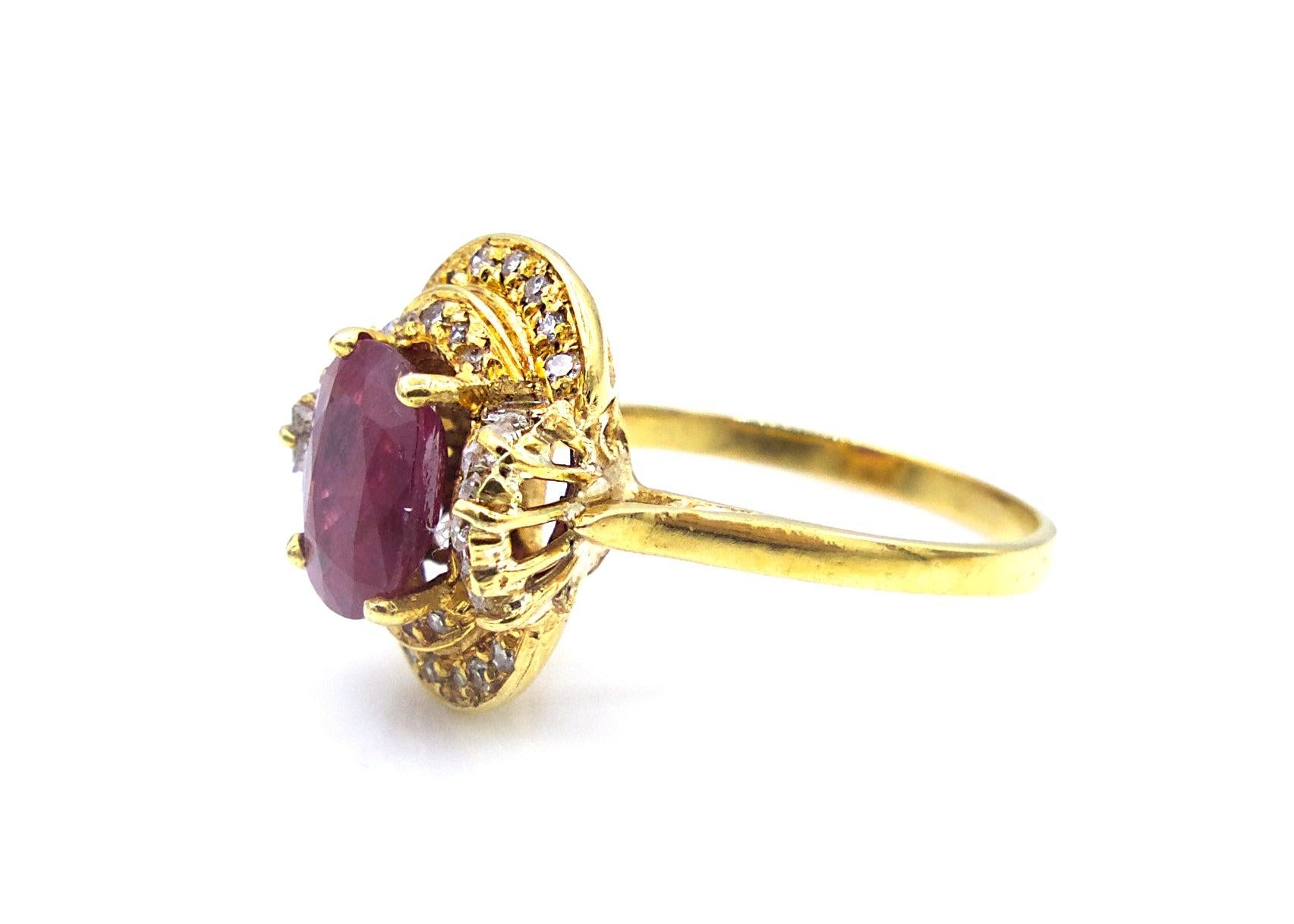 This faceted ruby ring is set in 18K yellow gold with the center stone surrounded by 12 baguette diamonds and 22 round cut diamonds. 

Size 6.5

4.3 g