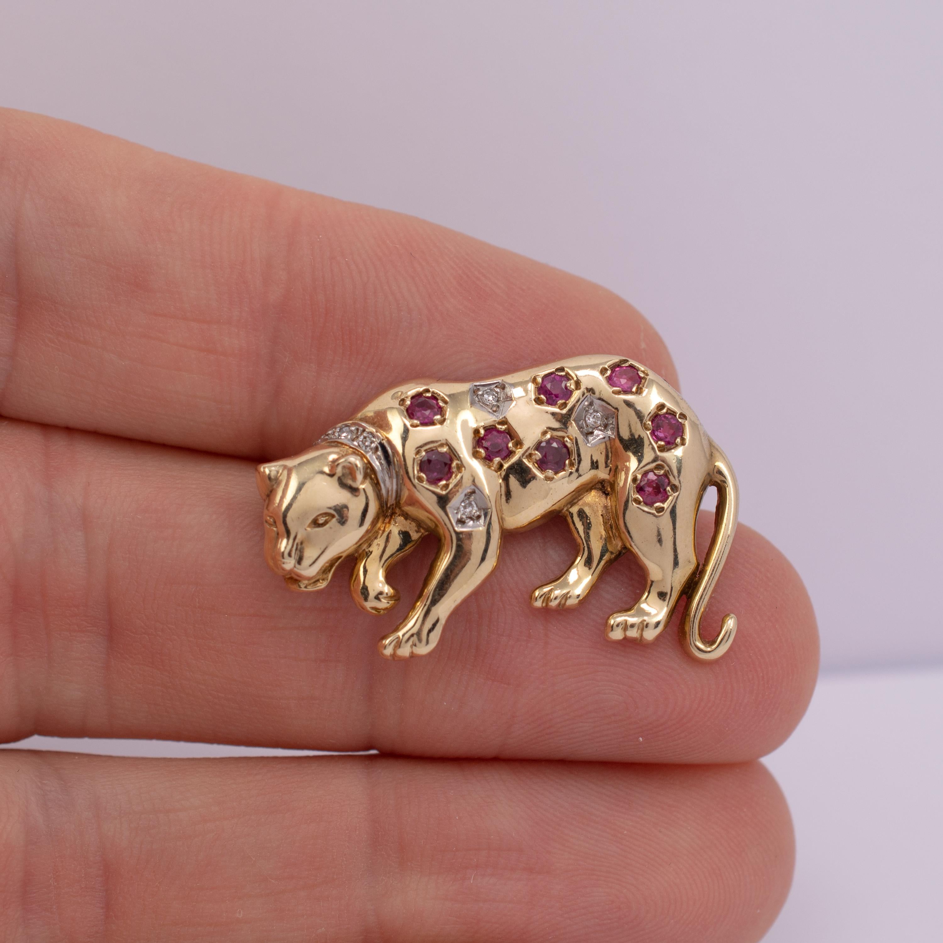 This fabulous 9 karat gold ruby and diamond brooch is modeled as a prowling leapard.

The smooth gold is adorned with 8 round 0.04ct paved set rubies and 3 x 0.03ct round diamonds deep set in white gold hexagons with smaller diamonds set into a