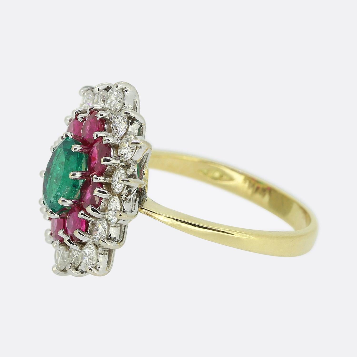 Nous avons ici une fabuleuse bague à plusieurs pierres précieuses. Une émeraude de forme ovale et de couleur vert vif est légèrement surélevée au centre du visage. Cette pierre principale est ensuite encadrée par une seule rangée de rubis ronds à