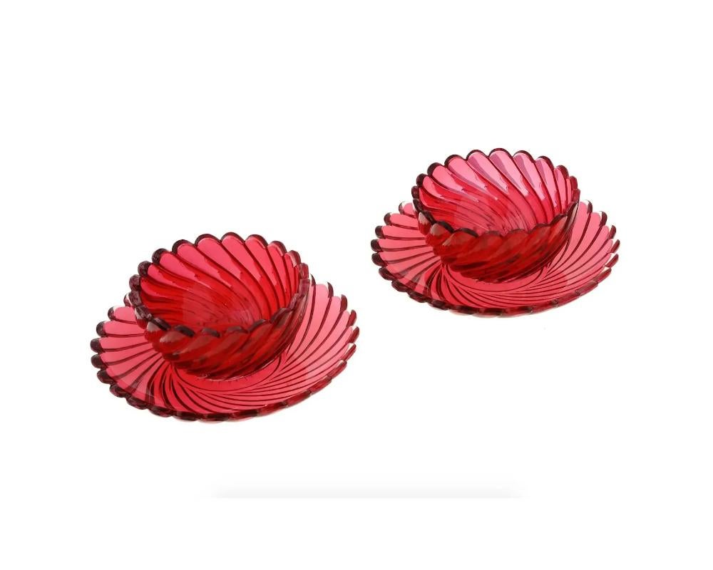A lot of vintage ruby red crystal Bohemian Glass tableware. A total of two bowls and two plates. The pieces have a swirl design with figurative rims. Collectible Glassware, Tableware And Serveware.

Dimensions: Plate D 7 1/4 in. D 4 4/8 in. H 2 1/2