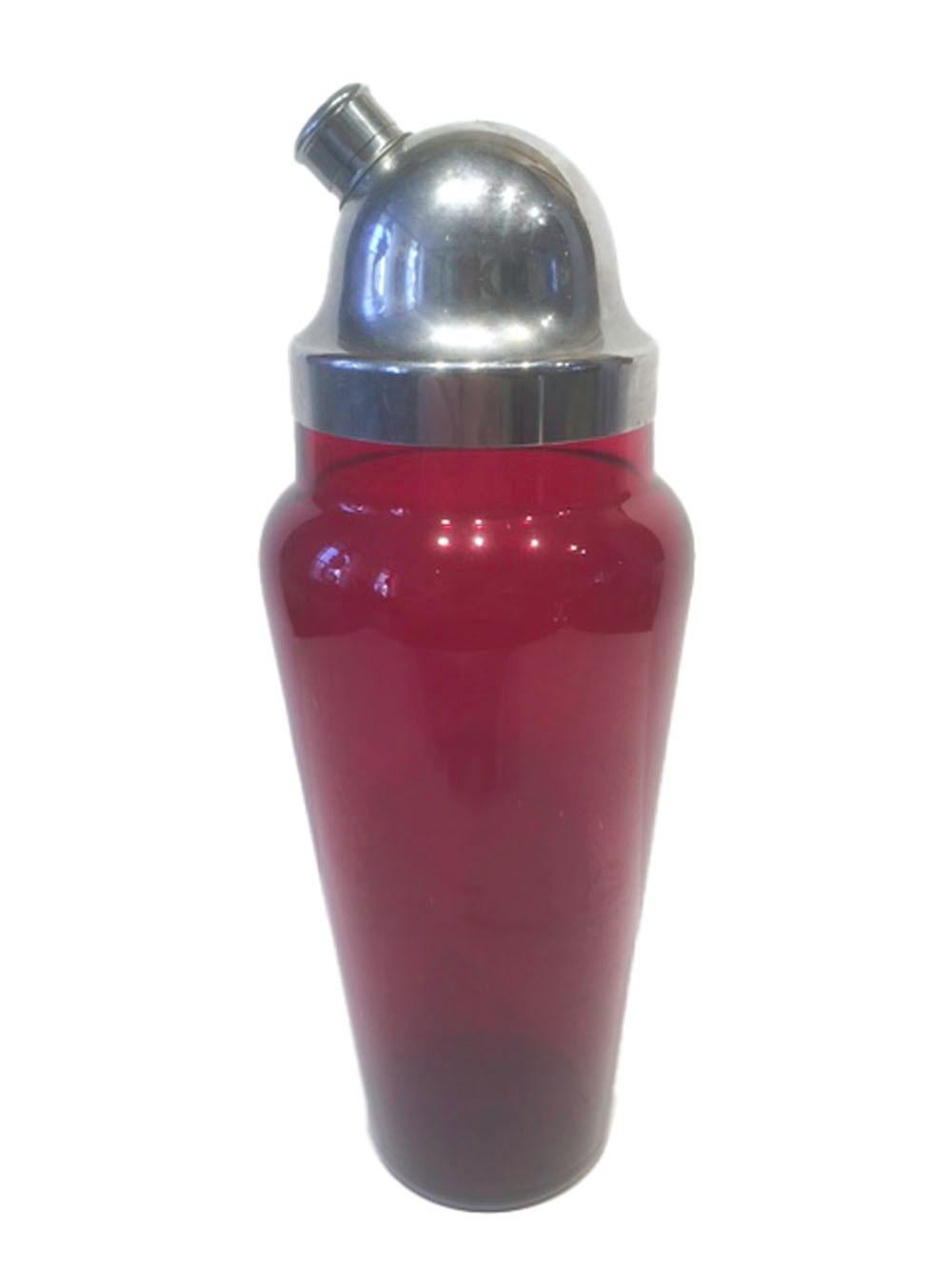 Art Deco ruby red glass cocktail shaker with a domed chrome lid having a pour spout with built in strainer. The body of the shaker tapers down from the rounded shoulder, The chrome lid fits snuggly to the neck of the shaker.