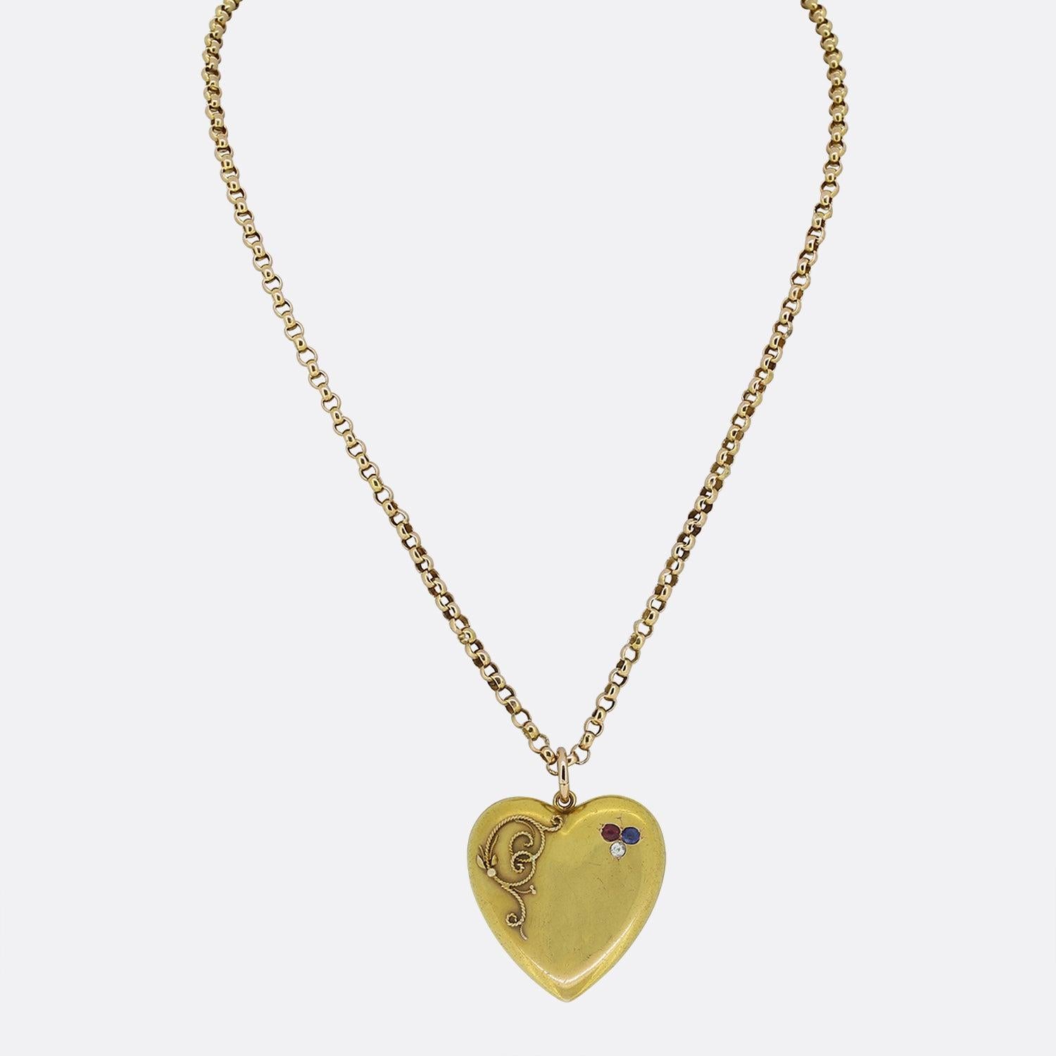 This is a beautiful antique Victorian heart pendant necklace. The pendant is heart shaped and has been set with a ruby, sapphire and diamond in a clover motif with a floral style rope effect on the left side of the heart. It has been crafted in 15ct