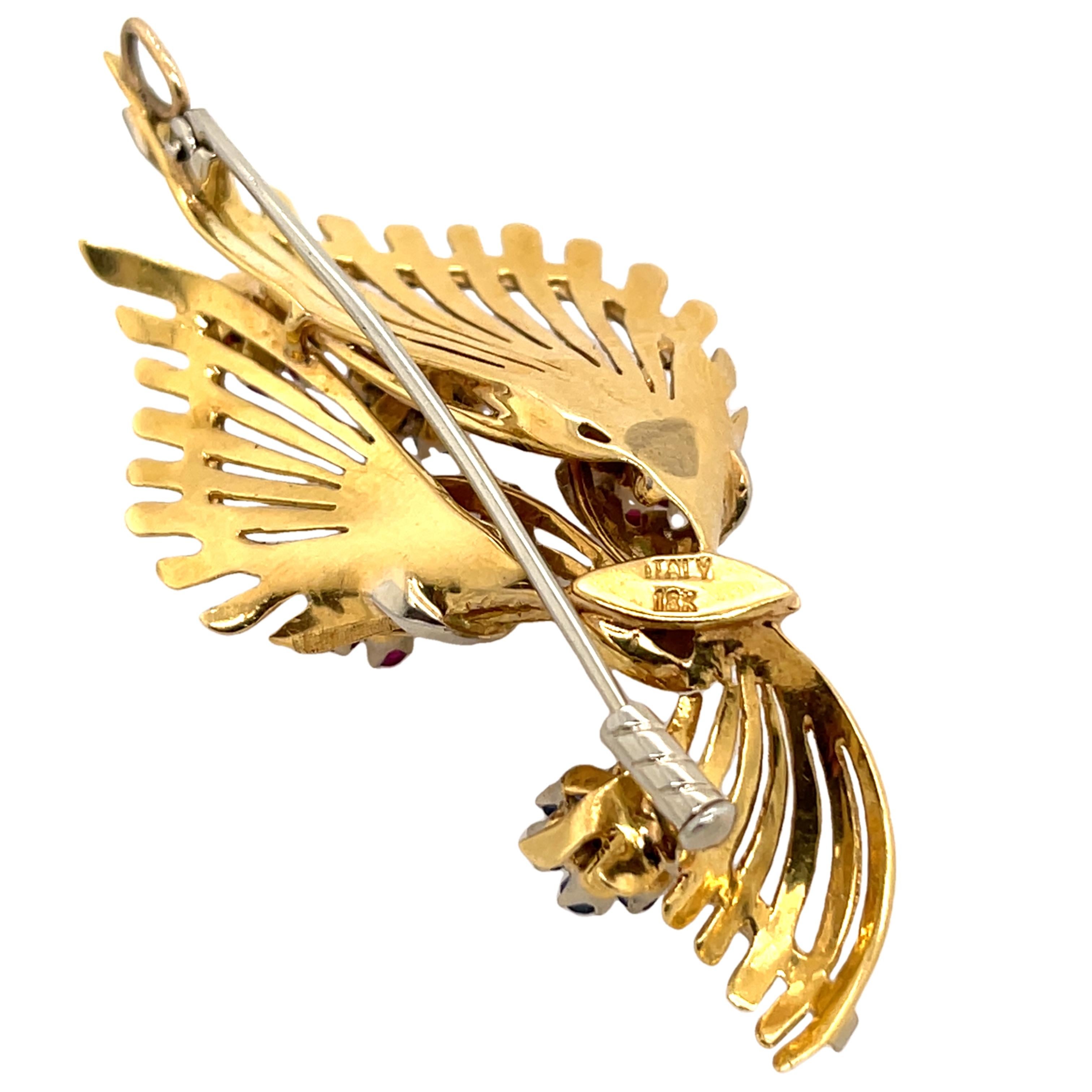Vintage Rubin & Saphir Brosche in 18ct Gelb- und Weißgold. Diese charmante Brosche besteht aus 21 lebhaften Rubinen und 14 Saphiren, die sorgfältig in eine elegante Kombination aus 18 Karat Gelb- und Weißgold gefasst sind. Ein zeitloses