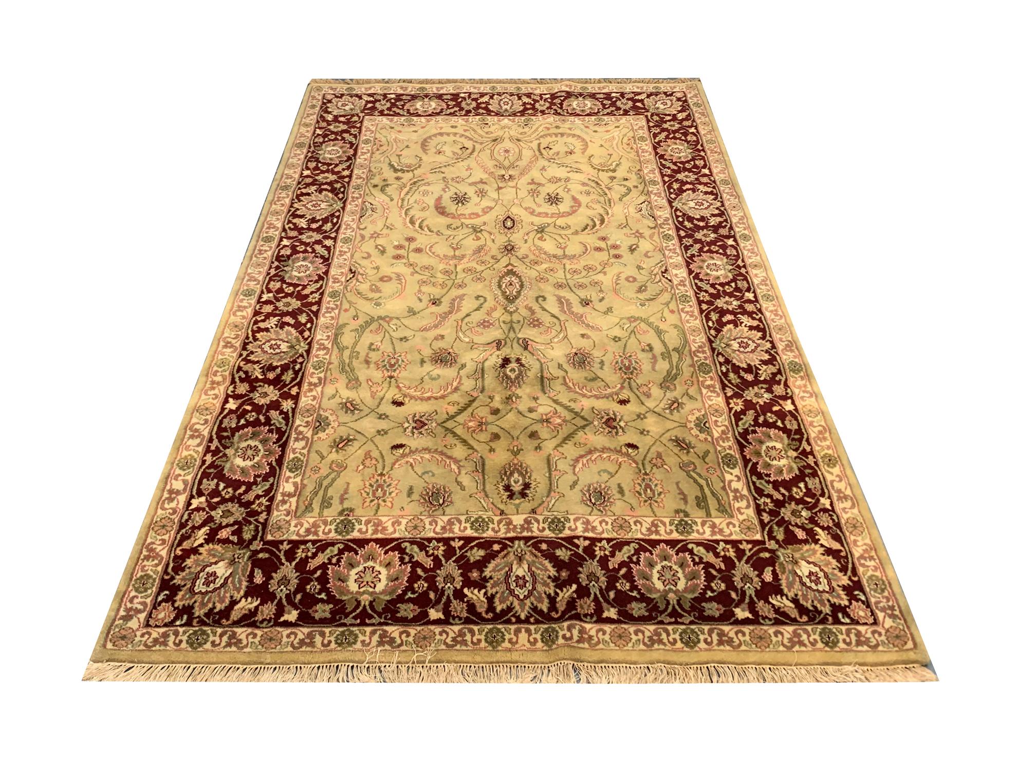 This fine wool oriental carpet is a vintage Ziegler rug woven by hand in India at the end of the 20th century, circa 1990. The central design features an elegant symmetrical pattern with delicate floral patterns woven in subtle accent colours