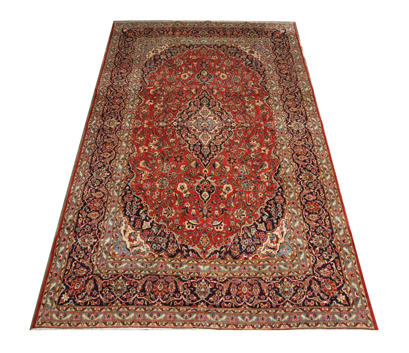This large oriental carpet is a wonderful example of Turkish carpets woven in the late 20th century. The central design has been woven on a rich red field with deep blue, green, beige and rust accents that make up the decorative medallion and floral