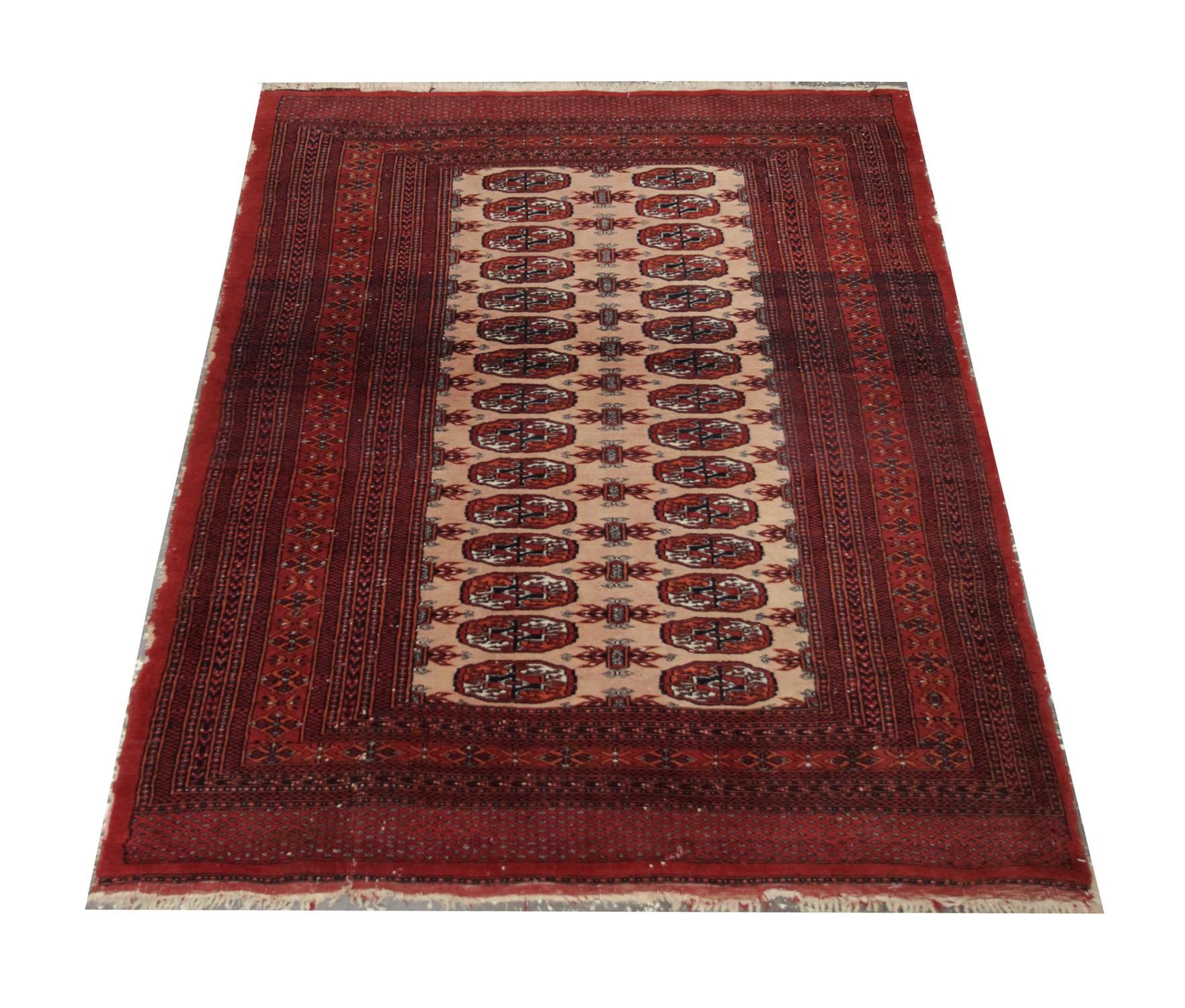 This vintage rug handmade carpet all-over design is a handwoven Turkmen rug. Handwoven with an oriental design featuring intricate octagons and stars through the centre on a cream background, enclosed by a deep red highly-detailed layered border