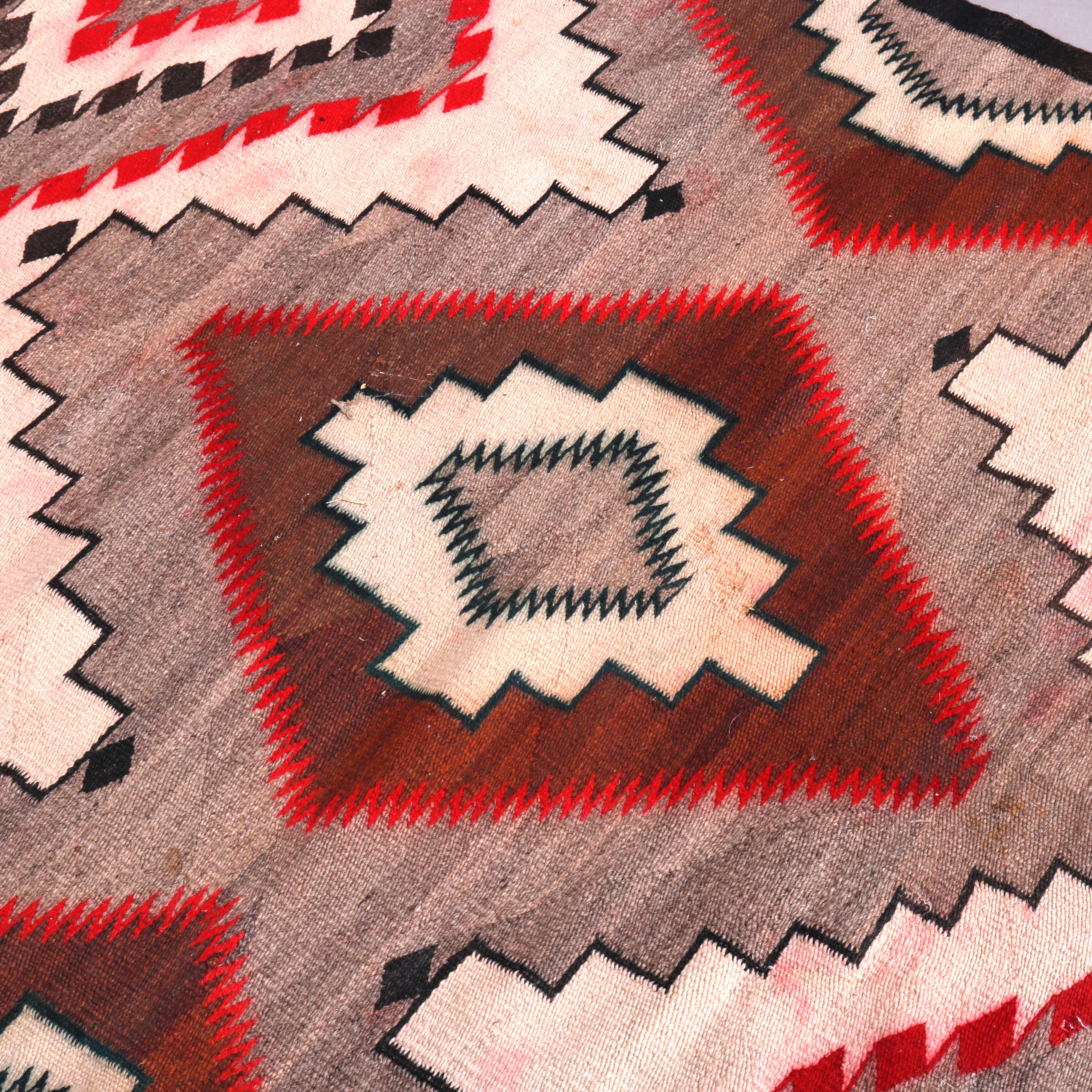 A vintage American Indian rug in the manner of Ganado Navajo weaving offers red, black and grey diamond design, 20th century

Measures: 60