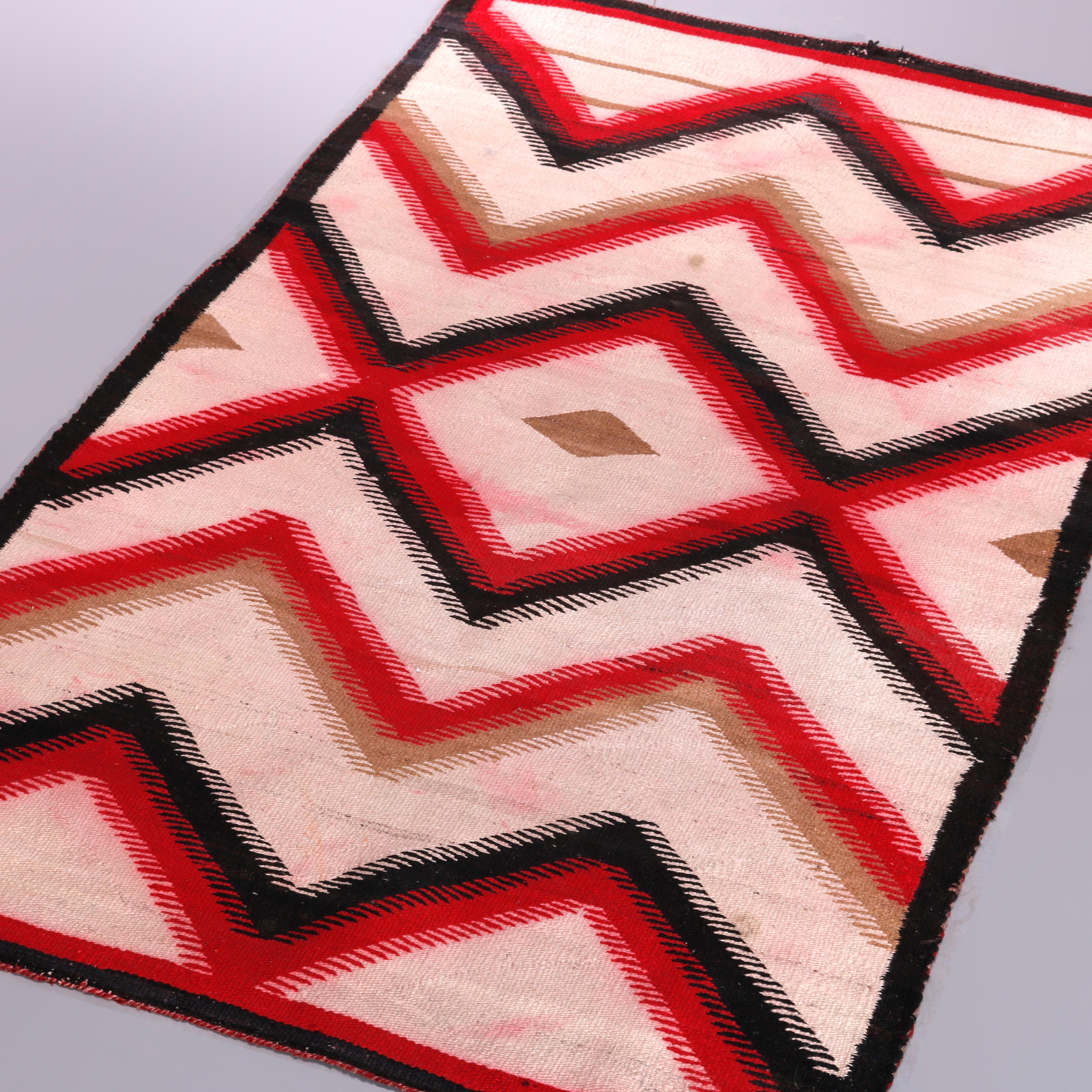 A vintage American Indian rug in the manner of Ganado Navajo weaving offers red, black and beige chevron design, 20th century

Measures: 58.5