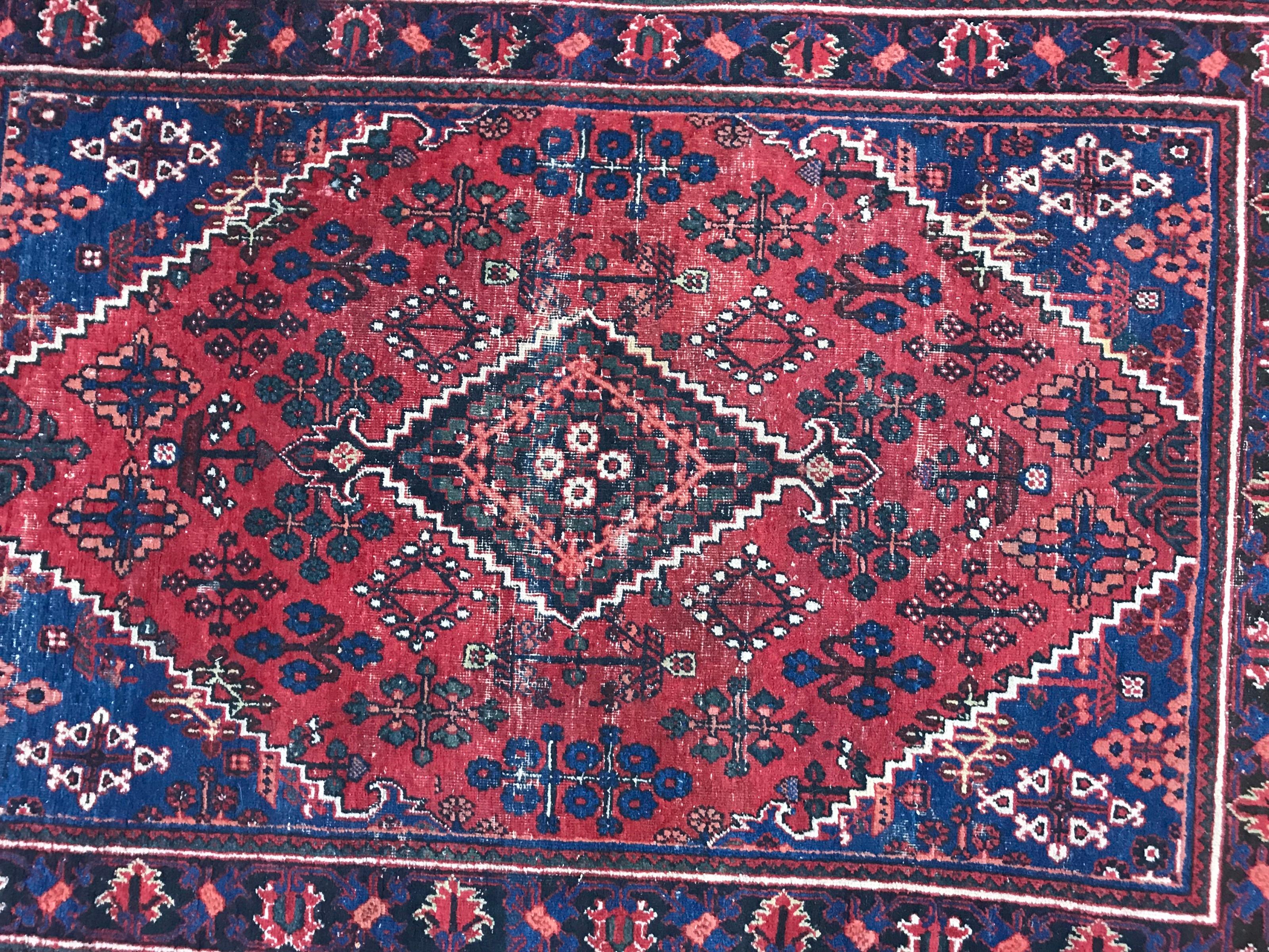 Beautiful mid-20th century rug with a nice geometrical design and red and blue colors, entirely hand knotted with wool velvet on cotton foundation.