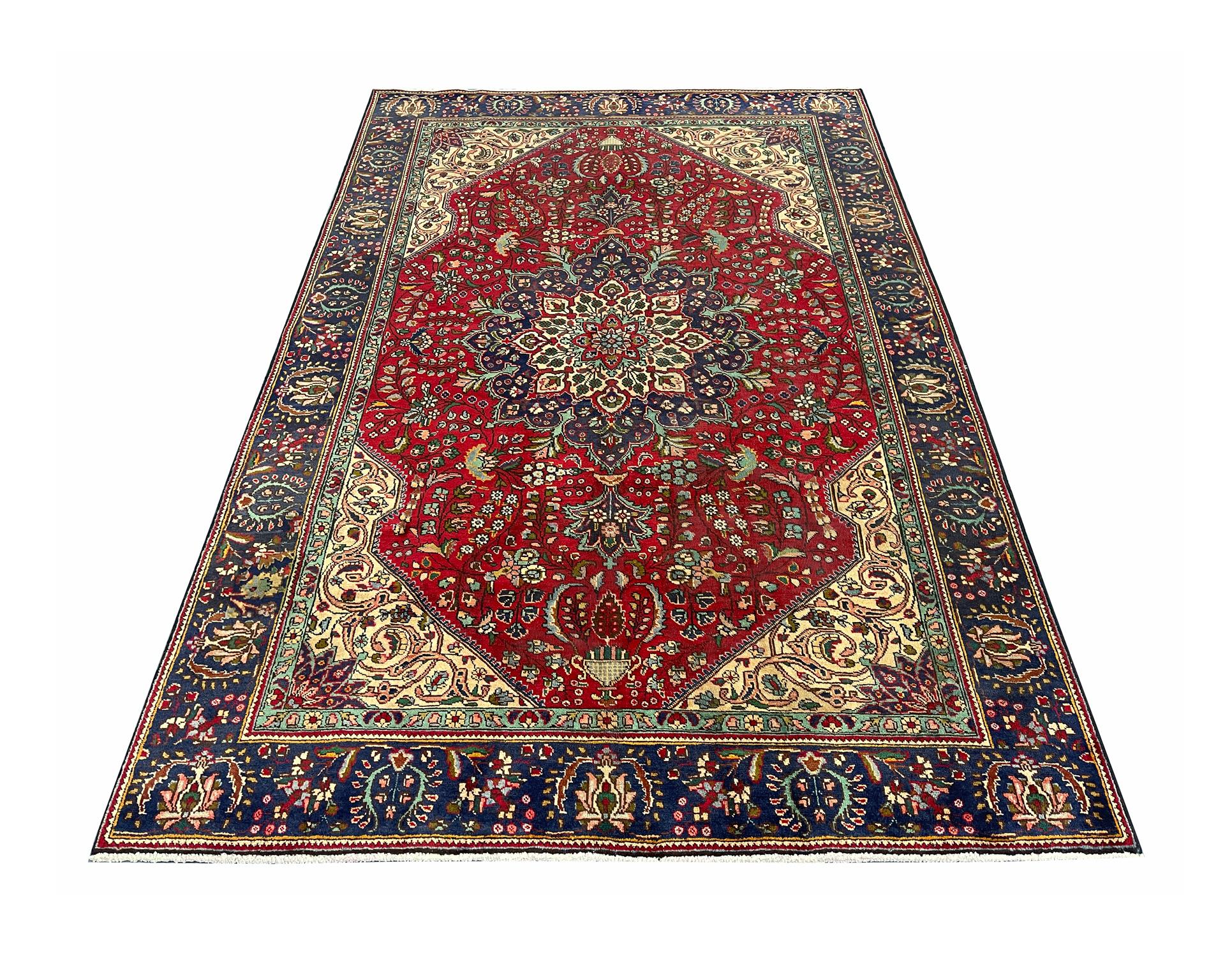 This unique wool area rug is a fantastic example of Turkish carpets woven in the late 20th century, circa 1970. The design features a large medallion and highly-decorative surrounding design. The rich red and blue colours used have been chosen to