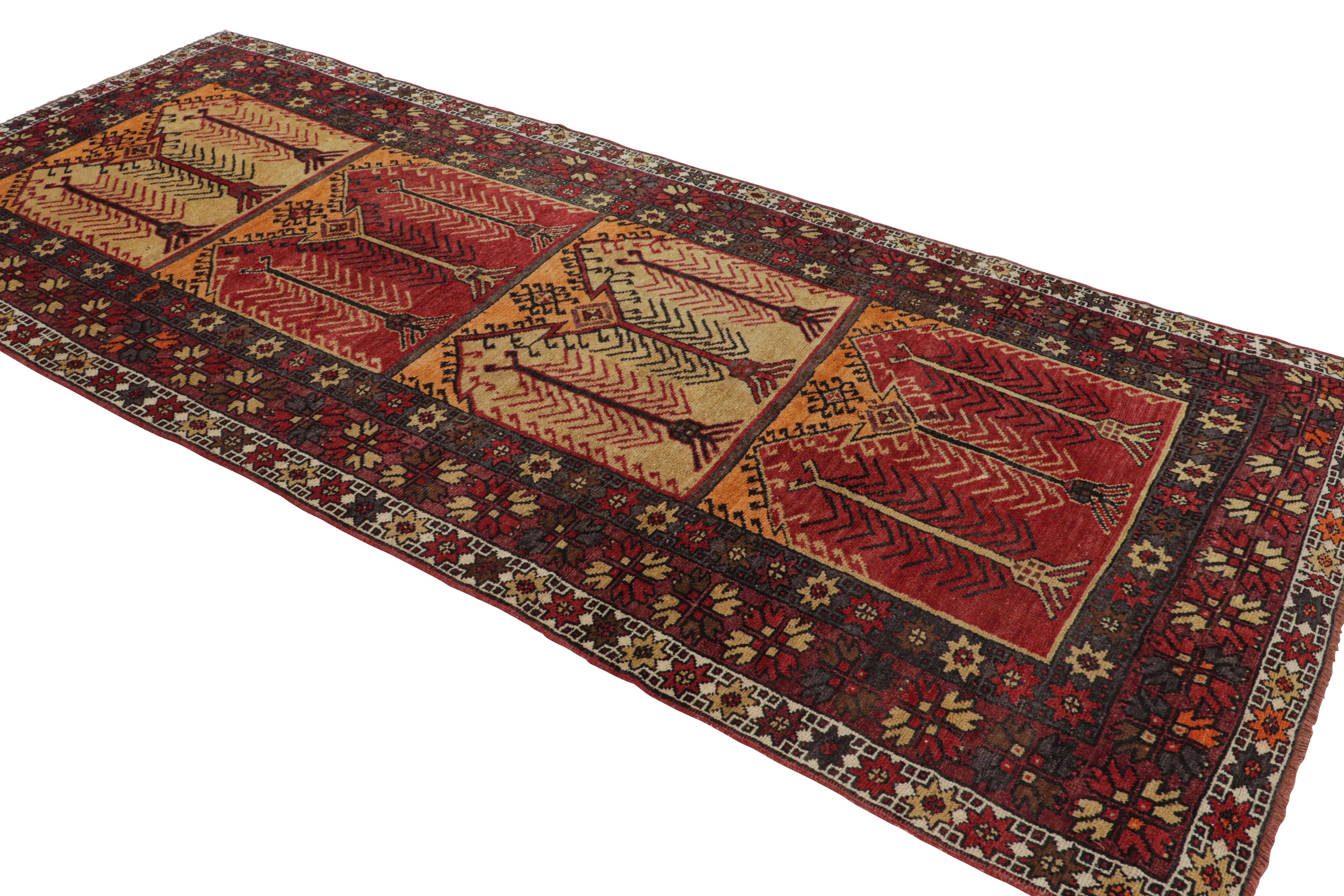 A midcentury red, black, and gold piece from the Konya region of Turkey, this geometric vintage wool rug features many intricate details with a lot of color and character-hand knotted in wool originating from Turkey, circa 1950-1960. The