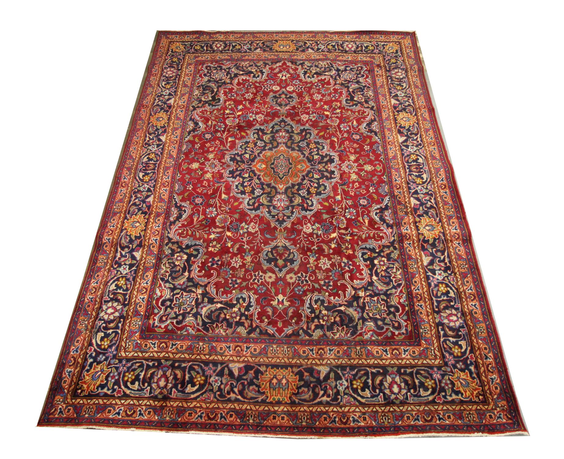 This unique wool area rug is a fantastic example of Turkish carpets woven in the late 20th century, circa 1970. The design features a large medallion and highly-decorative surrounding design. Woven with a bold red background with blue, brown and