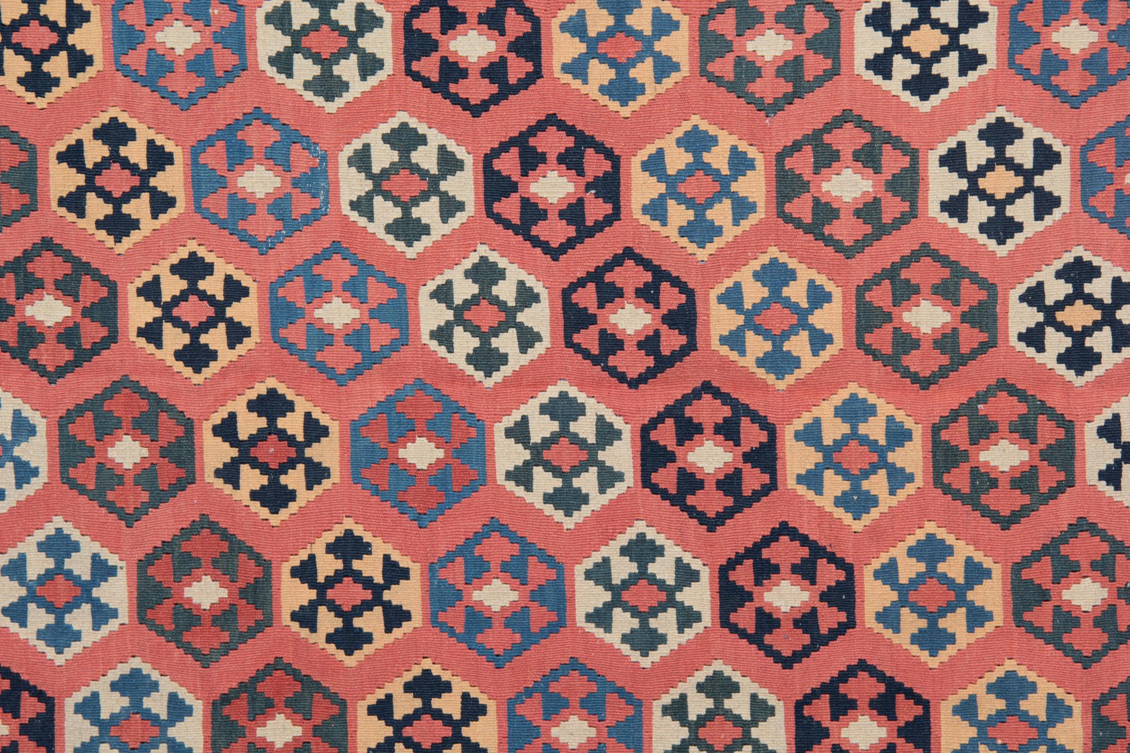 Dieser schöne antike Teppich zeigt ein einfaches rustikales Design, das mit den Grundfarben Rot, Blau und Gelb handgewebt wurde. Das Design ist geradlinig und minimalistisch, die Motive sind in kontrastierenden Farben gehalten. Perfekt sowohl für